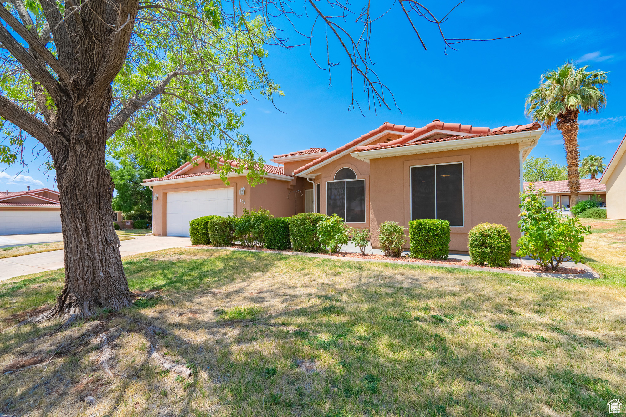 View of front of property with a garage and a front lawn