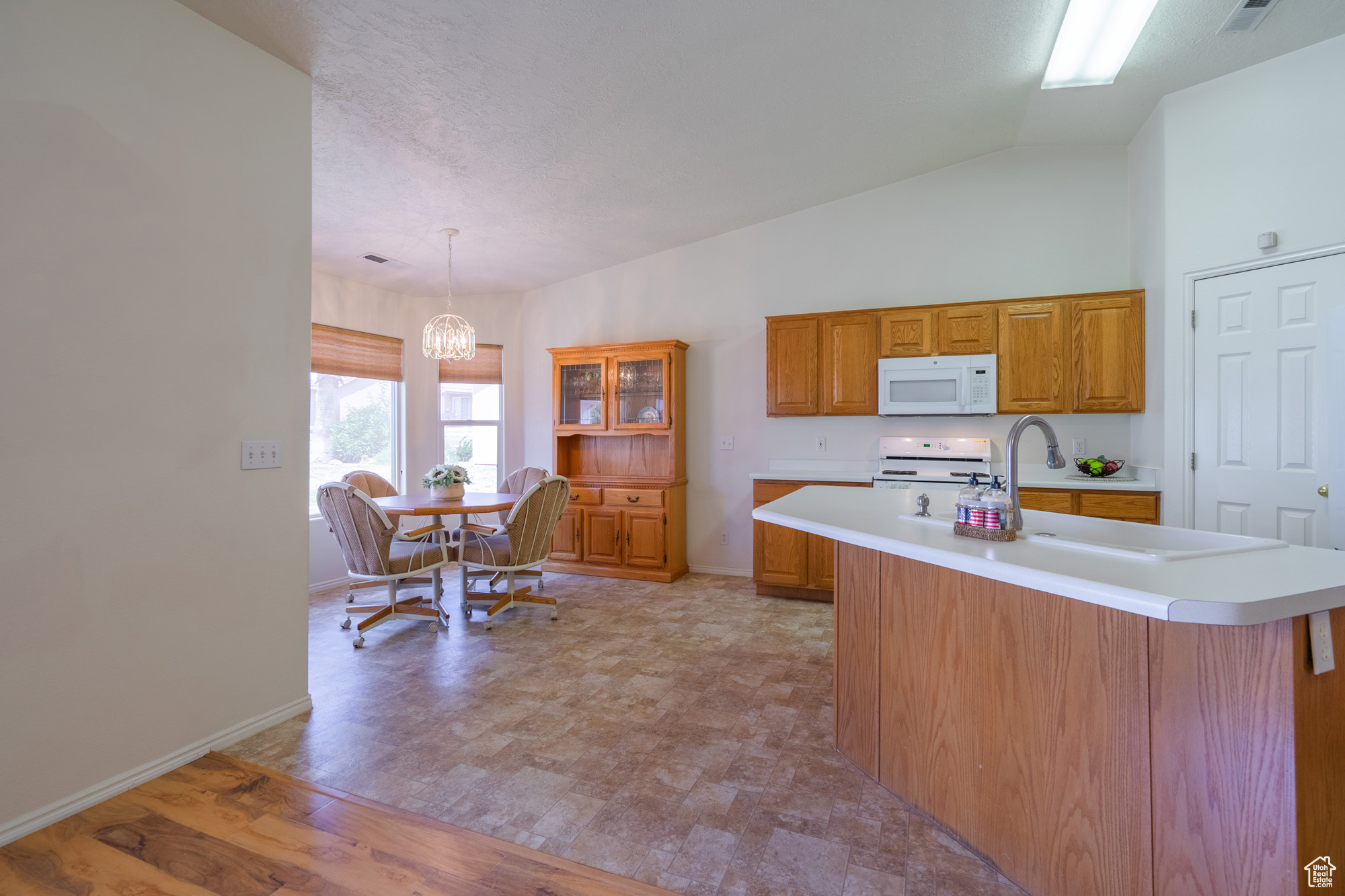 Kitchen featuring range, lofted ceiling, wood cabinets and kitchen island.