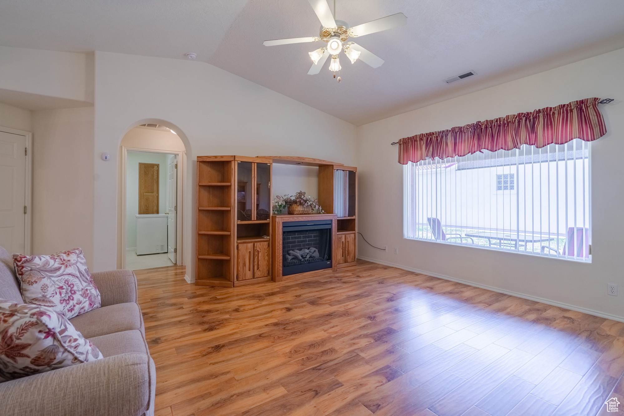 Living room with wood-type flooring, vaulted ceiling, and ceiling fan