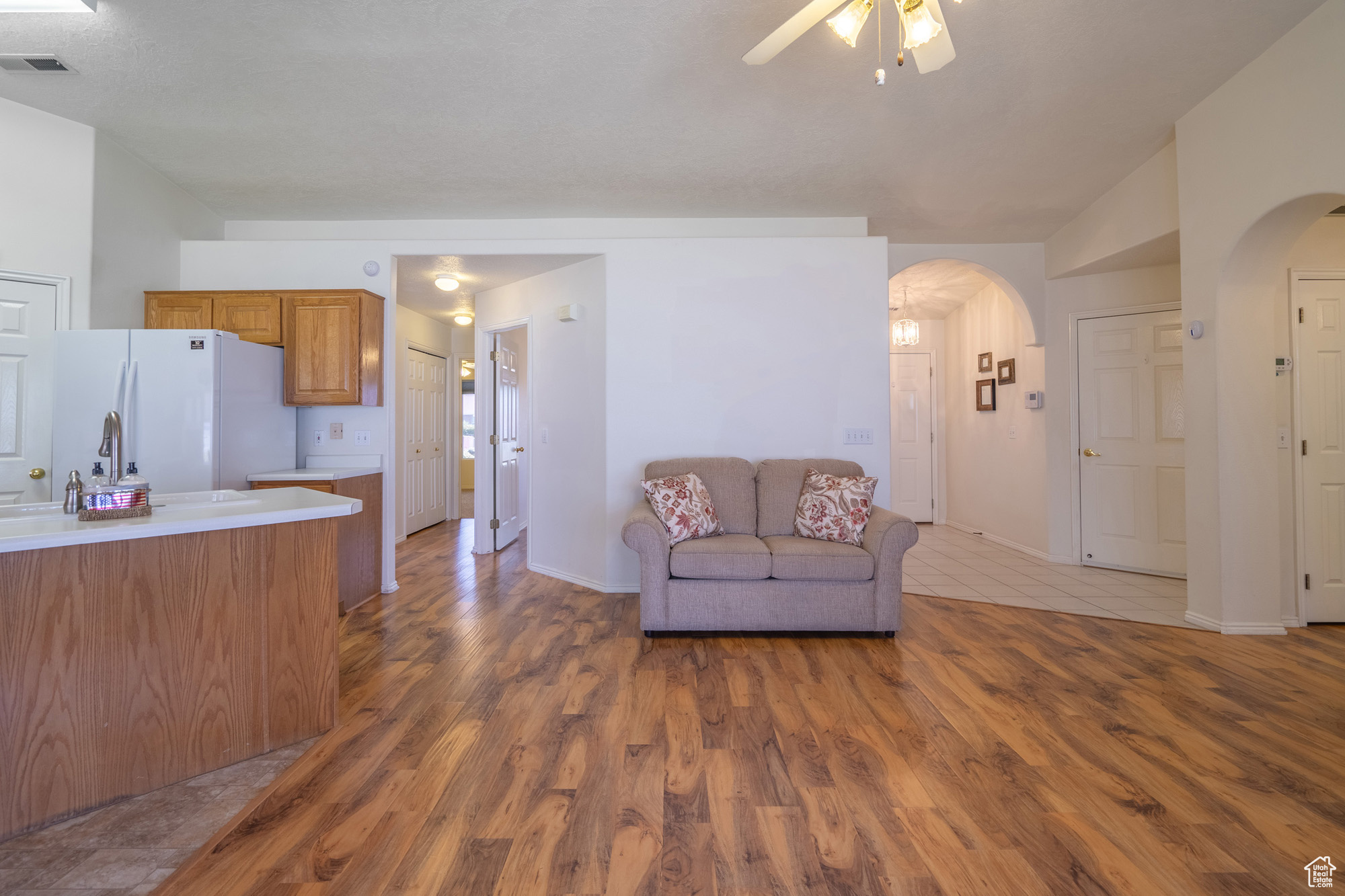 Living room with ceiling fan and hardwood / wood-style flooring