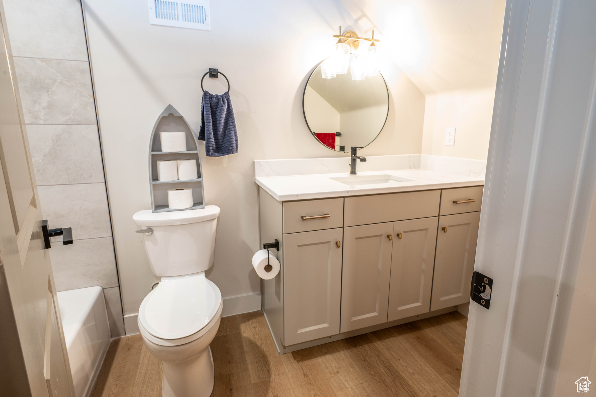 Attached to Bed 4 Full bathroom featuring tiled shower / bath combo, vanity, toilet, and hardwood / wood-style floors