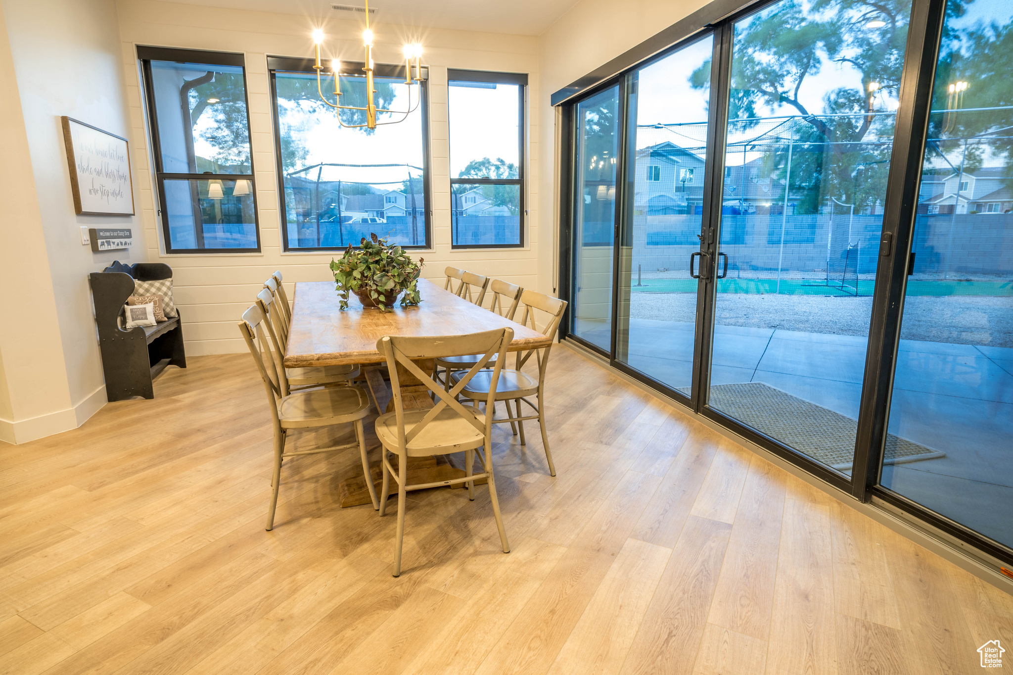 Dining space with light hardwood / wood-style flooring and a chandelier