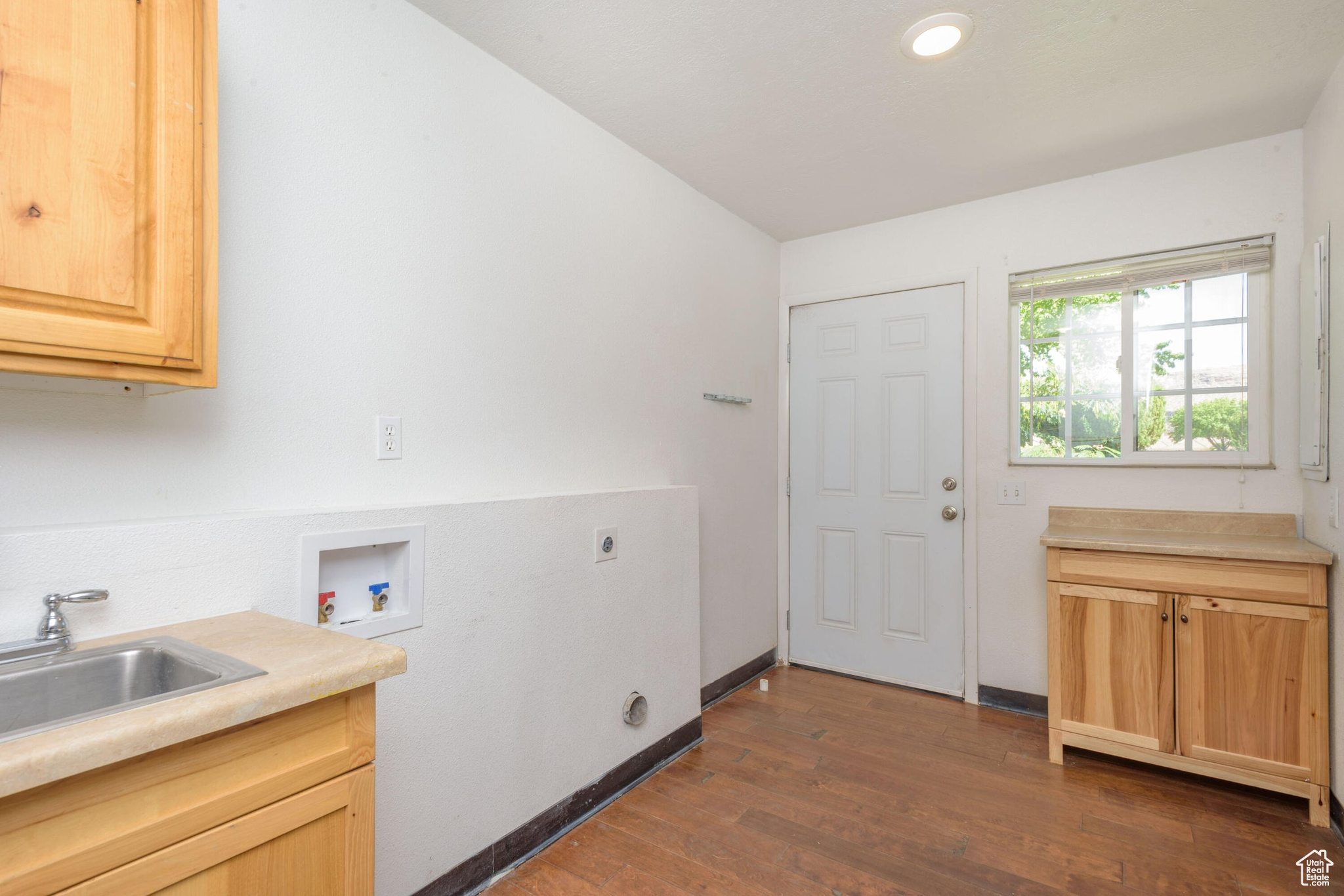 Laundry room featuring dark hardwood / wood-style flooring, sink, electric dryer hookup, cabinets, and washer hookup