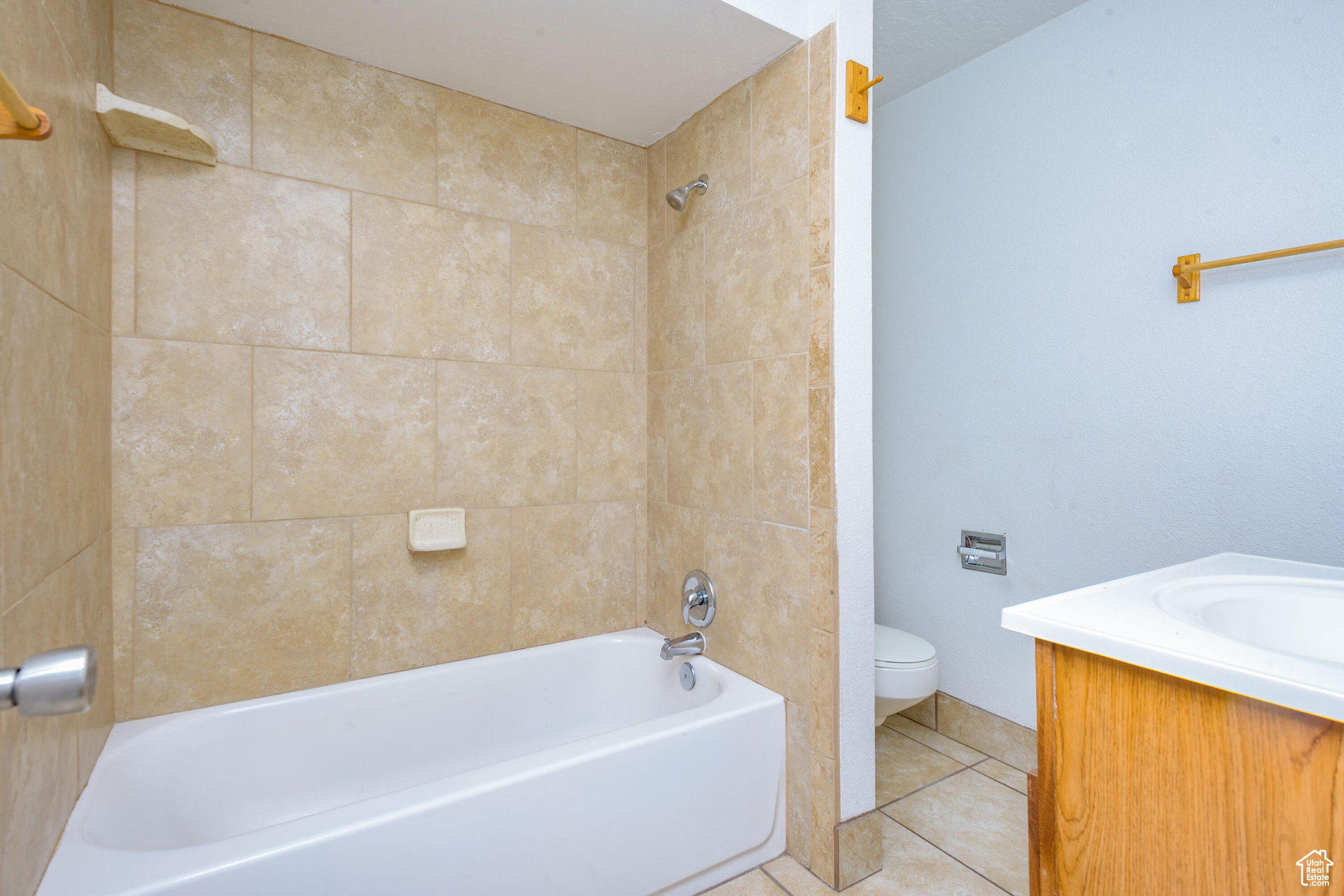 Full bathroom featuring vanity, tile patterned flooring, tiled shower / bath combo, and toilet