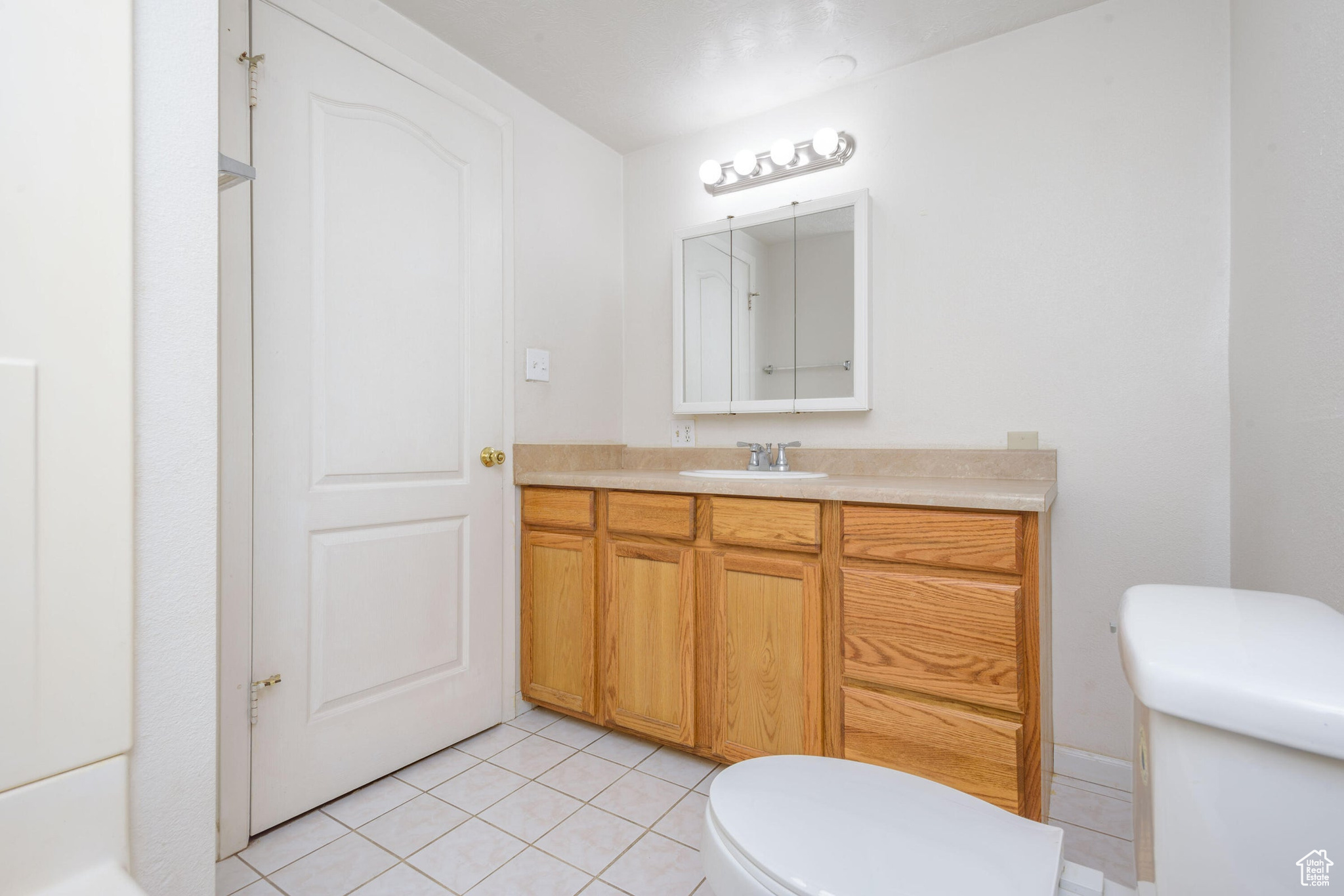 Bathroom with tile patterned floors, toilet, and vanity