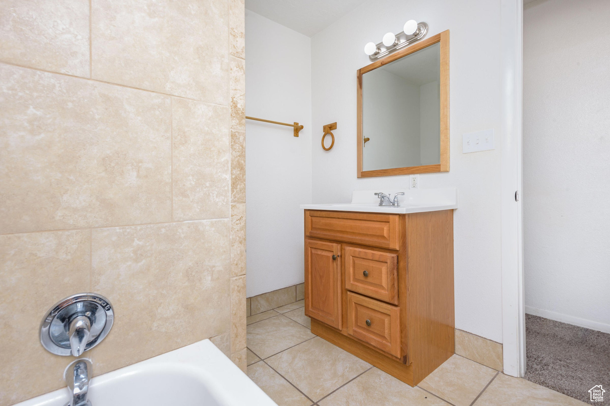 Bathroom with vanity, tile patterned flooring, and a bathing tub