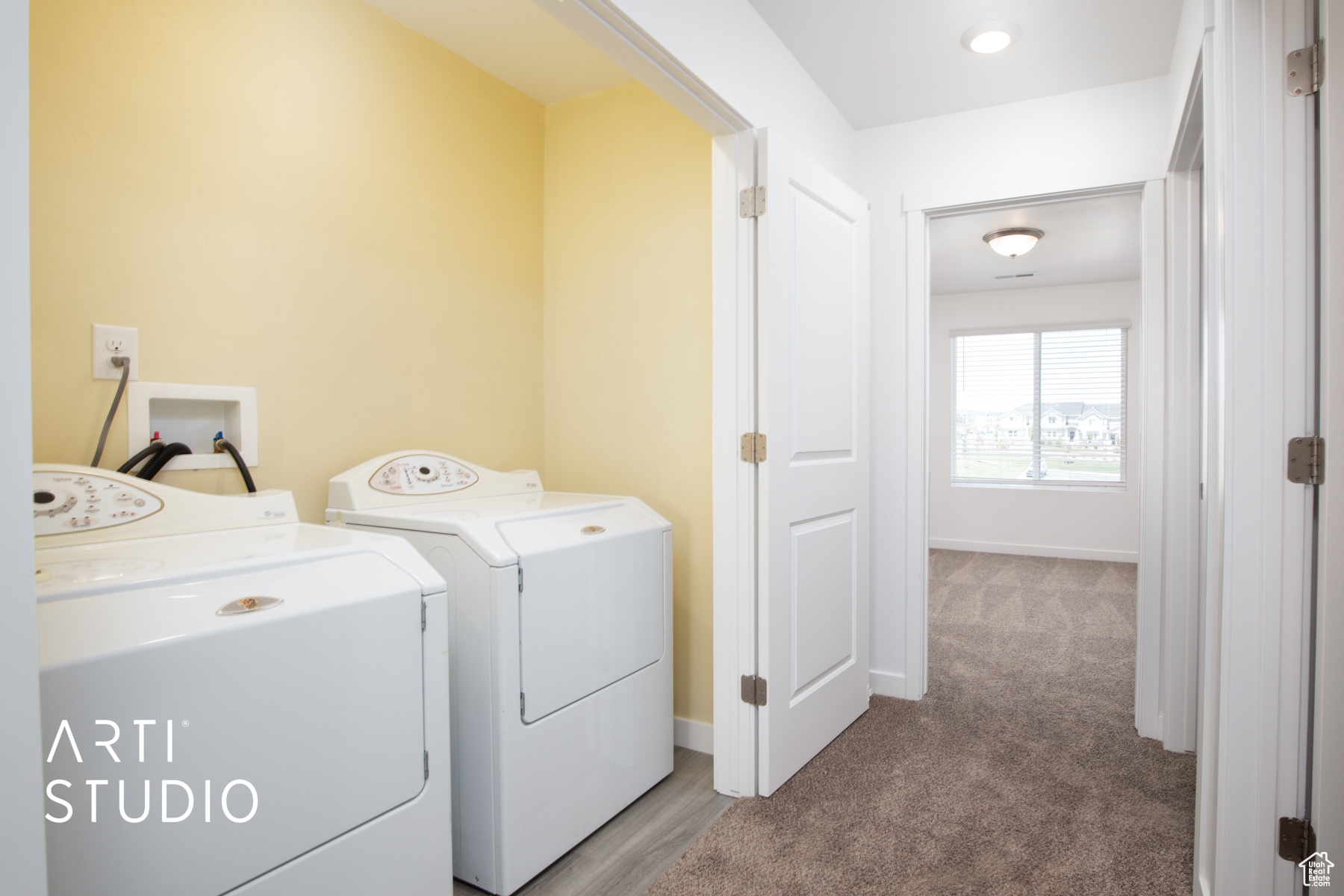 Laundry area with washing machine and dryer and carpet