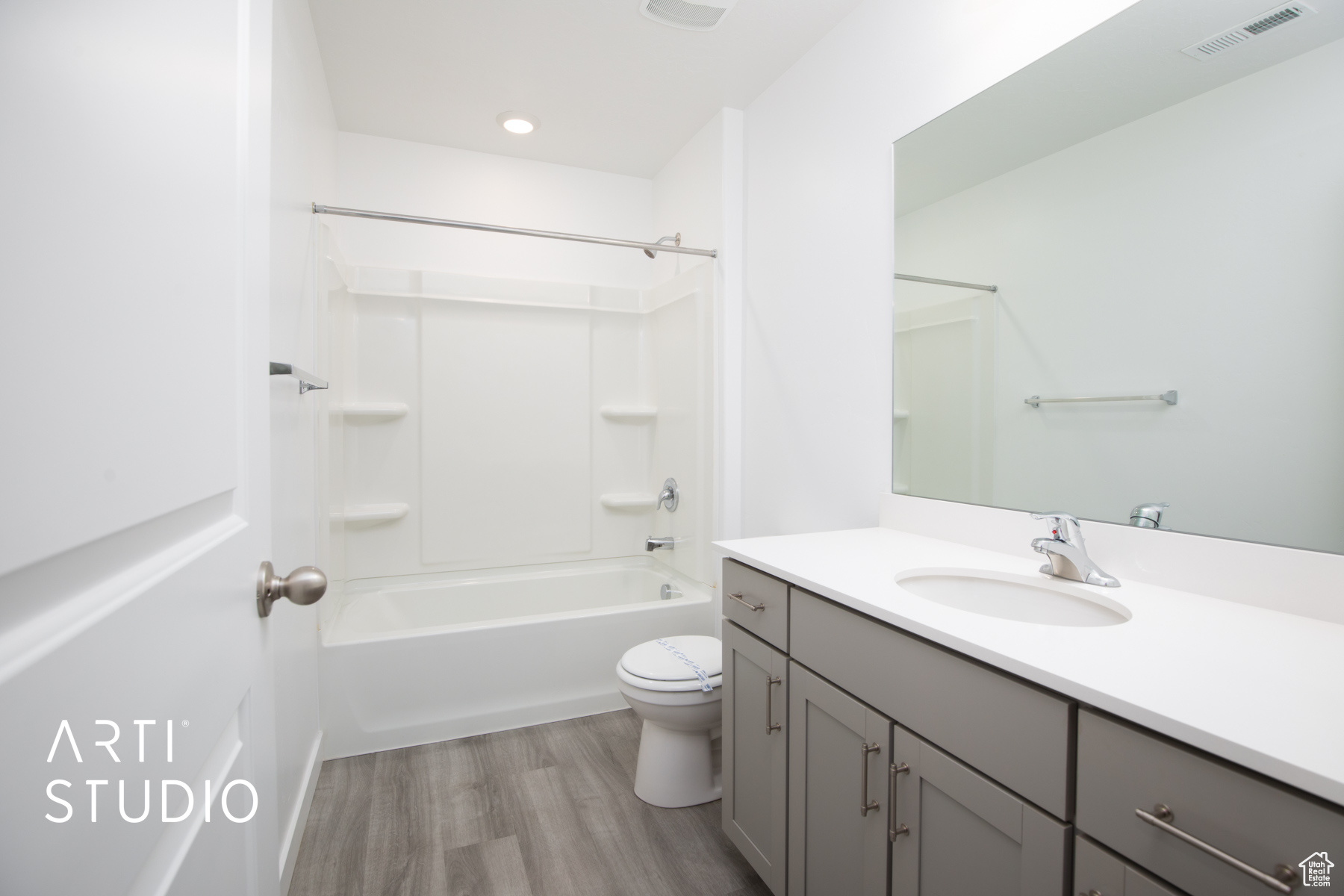 Full bathroom featuring wood-type flooring, bathtub / shower combination, toilet, and vanity