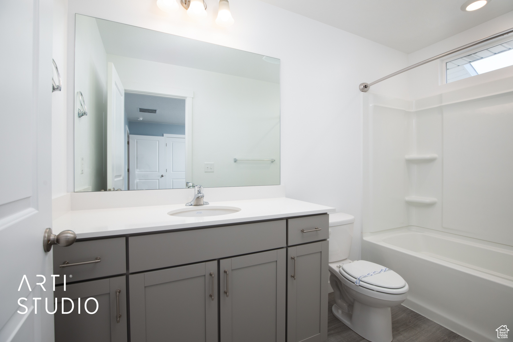 Full bathroom featuring vanity, wood-type flooring,  shower combination, and toilet