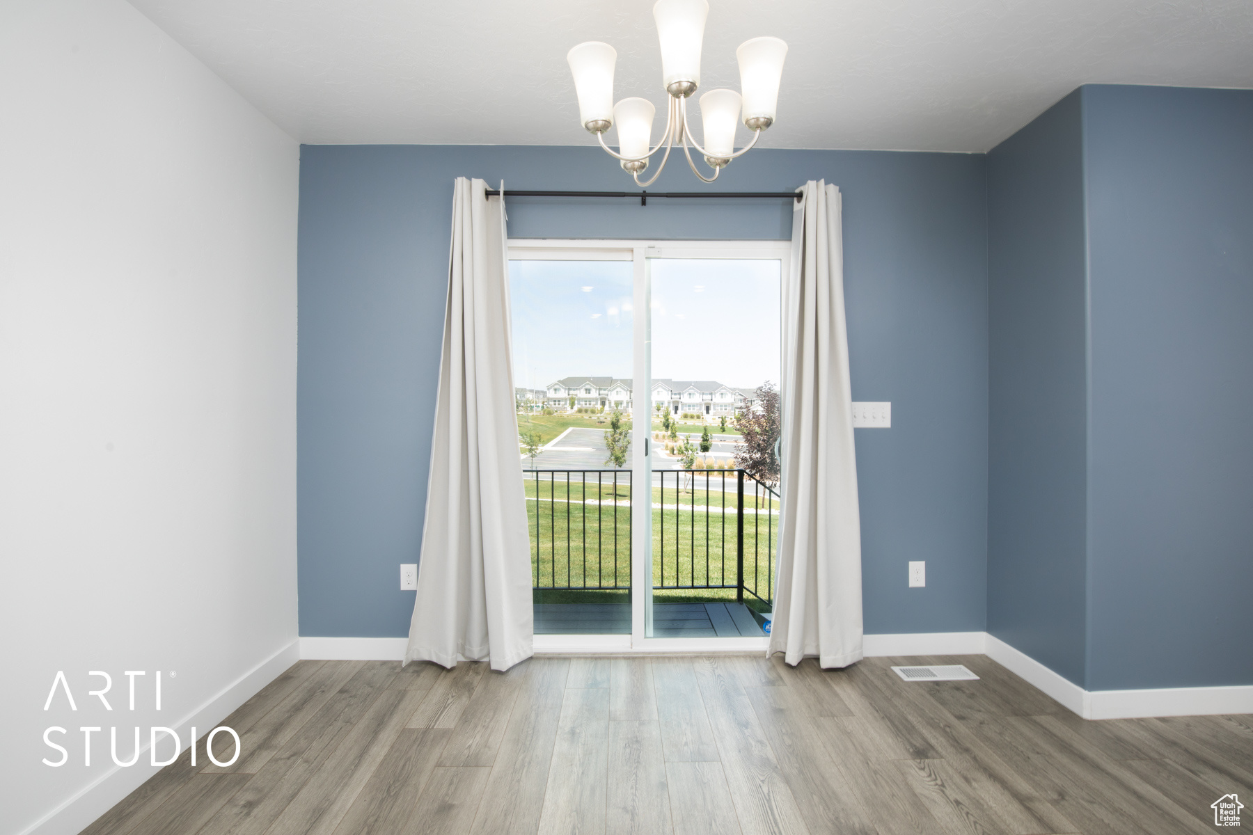 Unfurnished room featuring hardwood / wood-style flooring and a chandelier