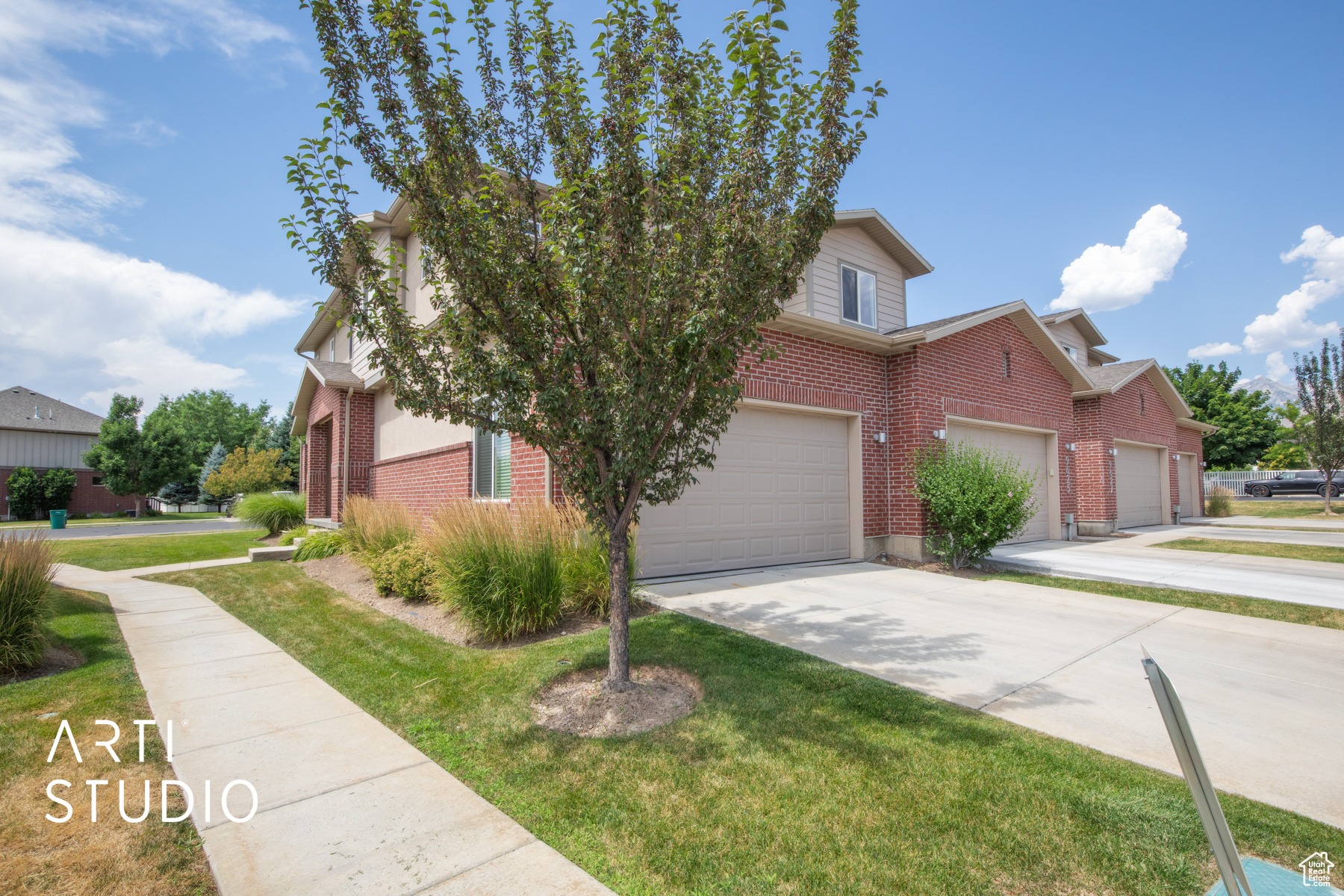 View of front of property featuring a garage and a front lawn