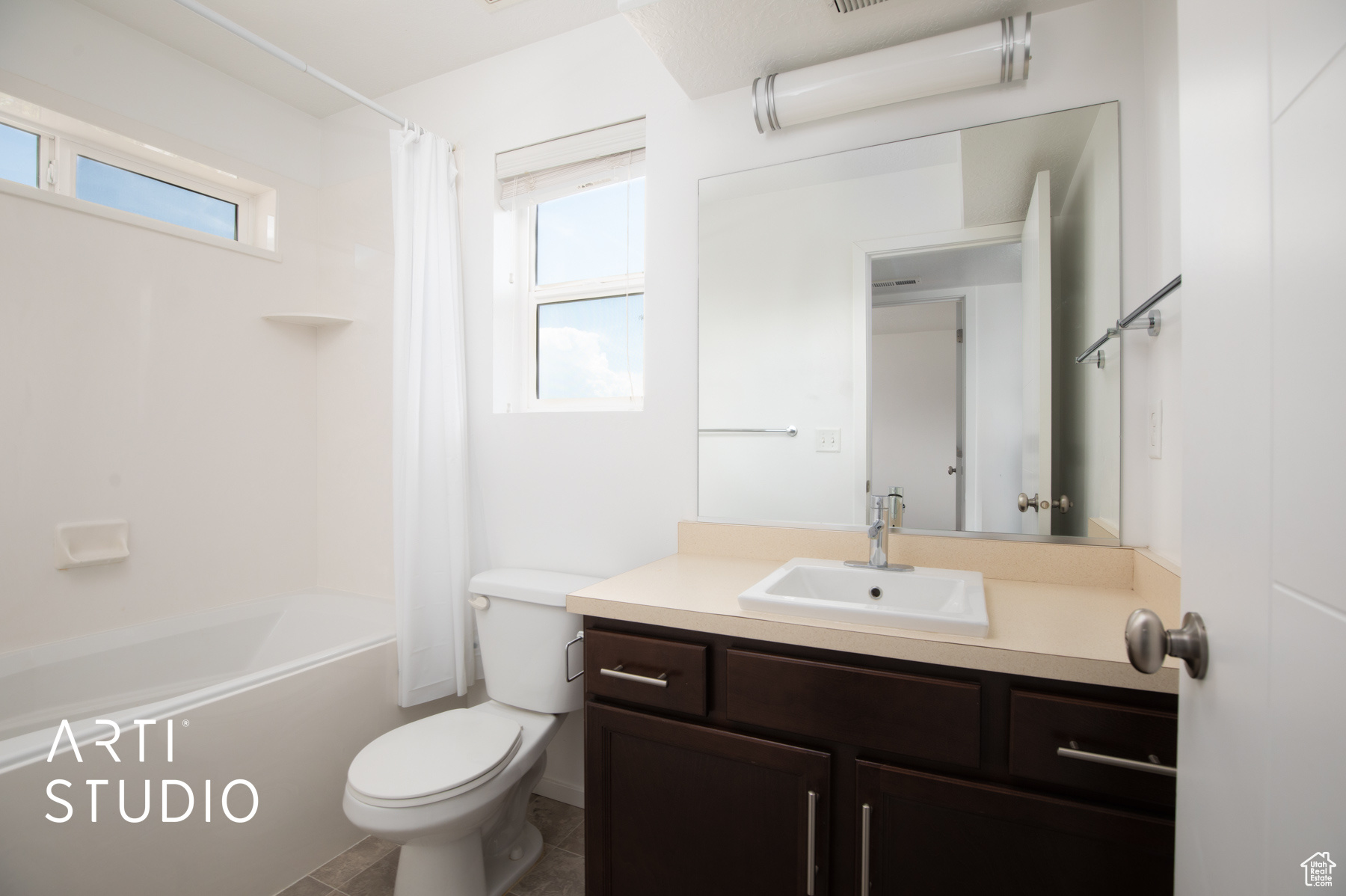 Full bathroom with plenty of natural light, vanity, toilet, and shower / tub combo with curtain