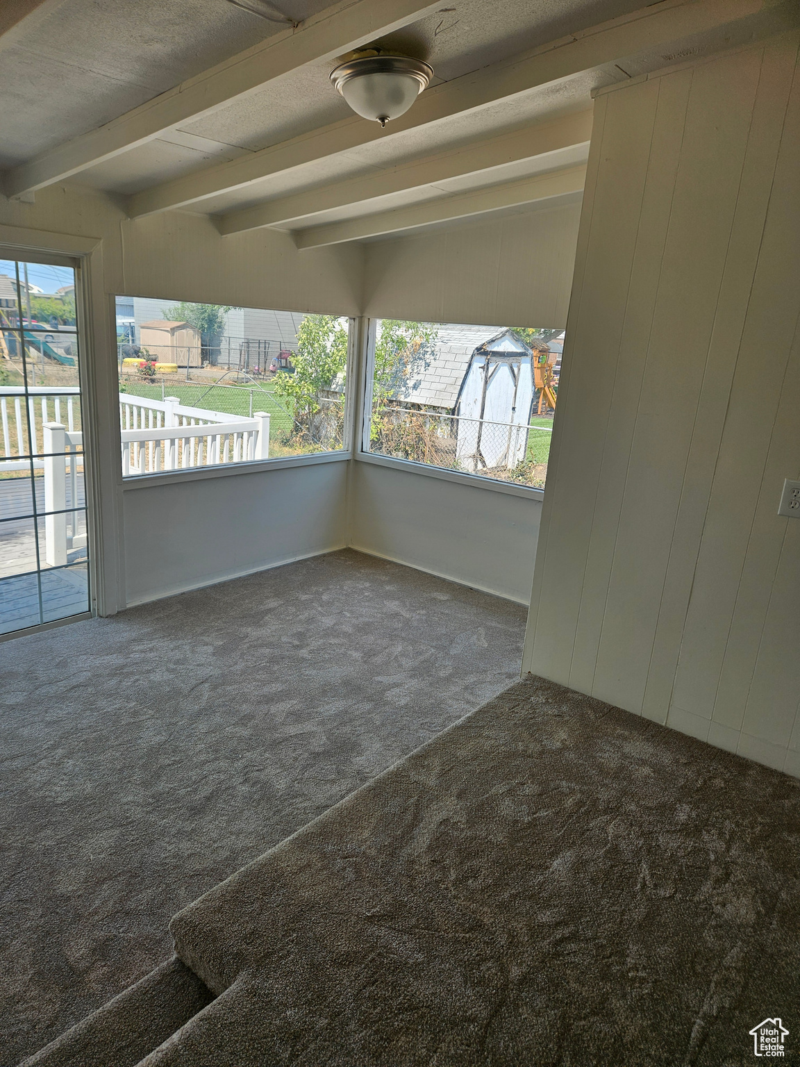 Unfurnished room with carpet floors and beamed ceiling