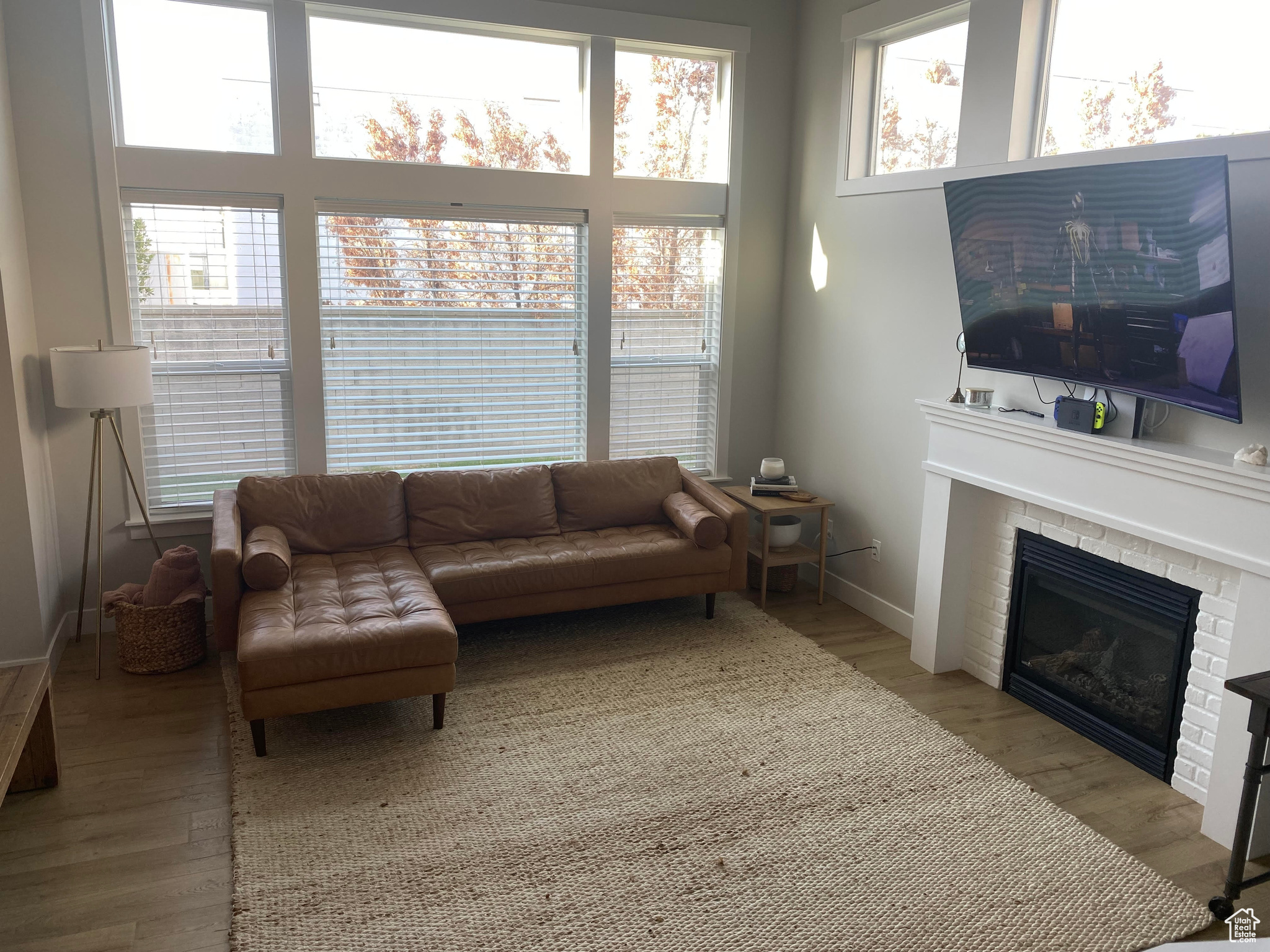 Living room with light hardwood / wood-style flooring and a brick fireplace