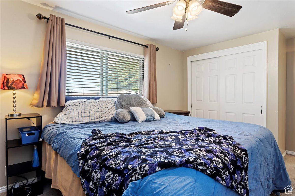 Bedroom featuring carpet, ceiling fan, and a closet