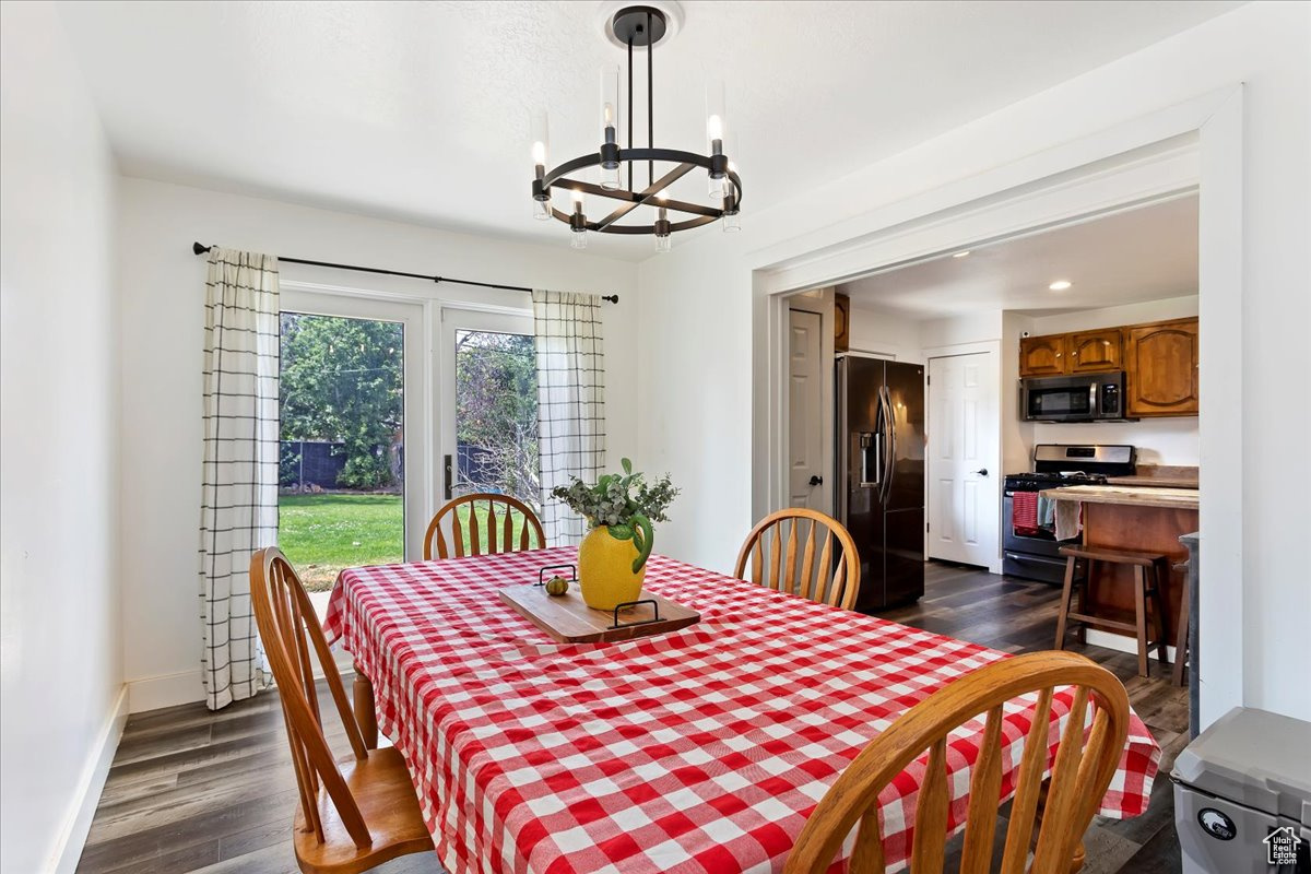 Dining room featuring dark wood-type flooring and an inviting chandelier