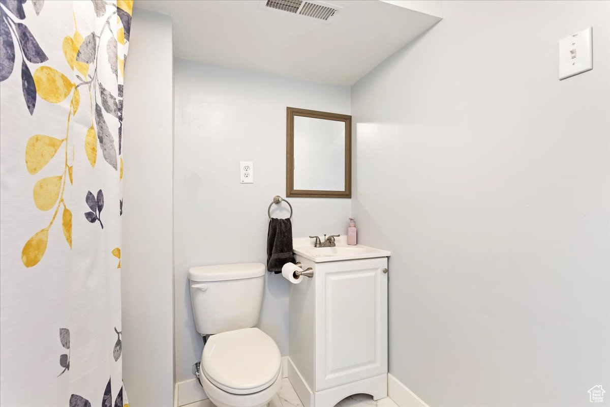 Bathroom featuring tile patterned floors, toilet, and vanity