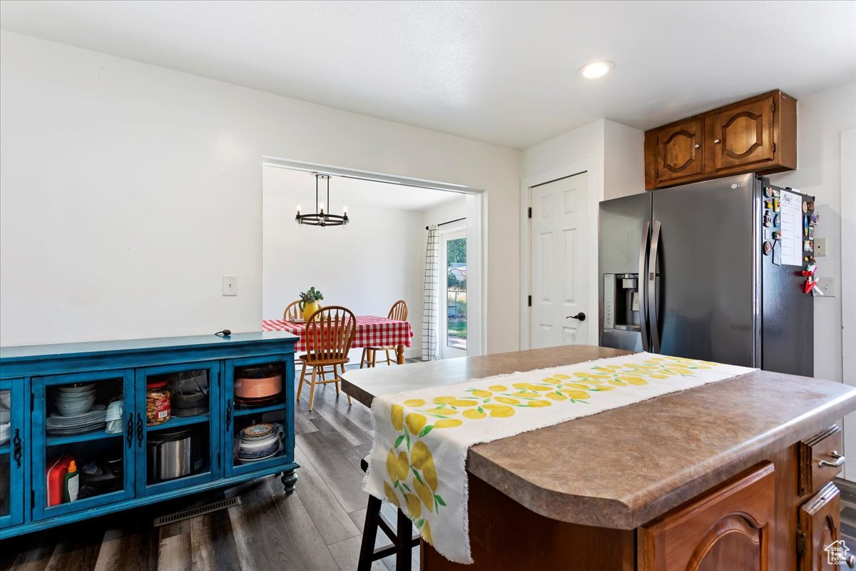 Kitchen featuring dark hardwood / wood-style floors, stainless steel fridge, and hanging light fixtures