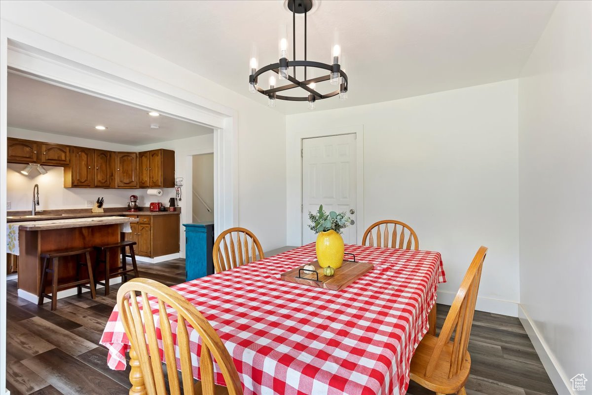 Dining space with a notable chandelier, dark hardwood / wood-style flooring, and sink