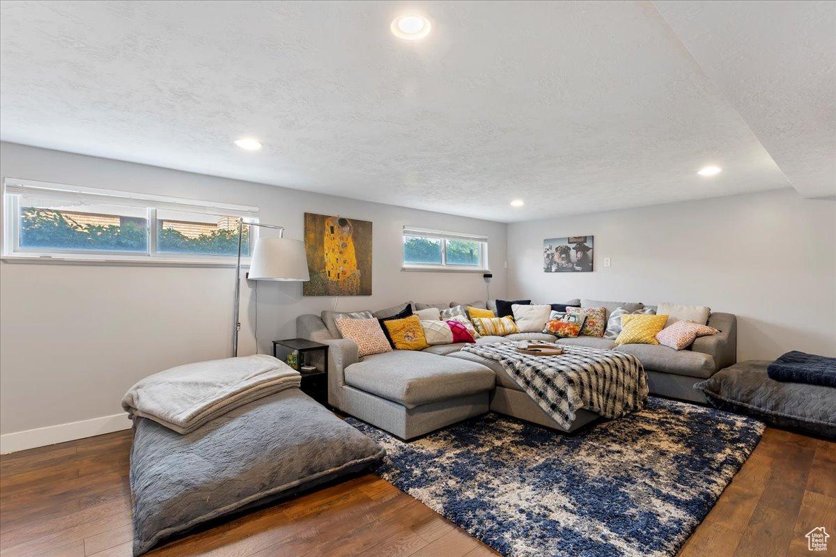 Living room with a textured ceiling and wood-type flooring