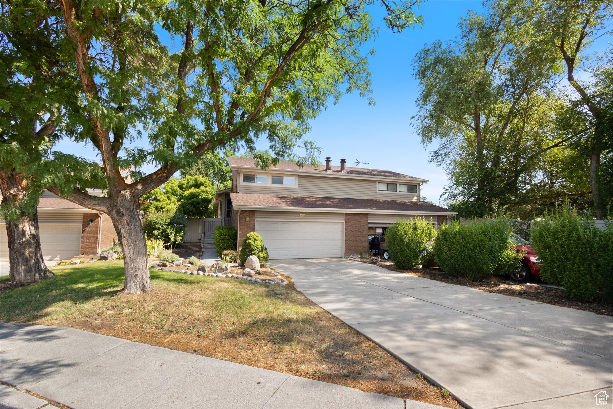 View of front property featuring a garage and a front lawn