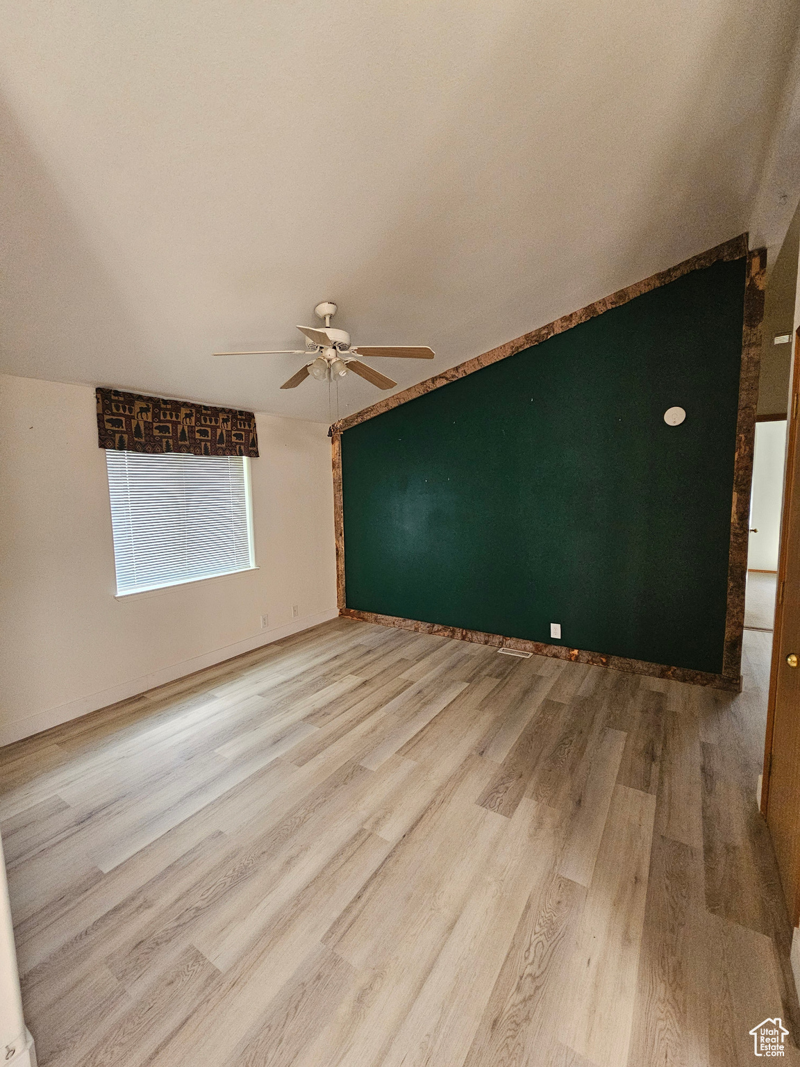 Empty room with light wood-type flooring and ceiling fan