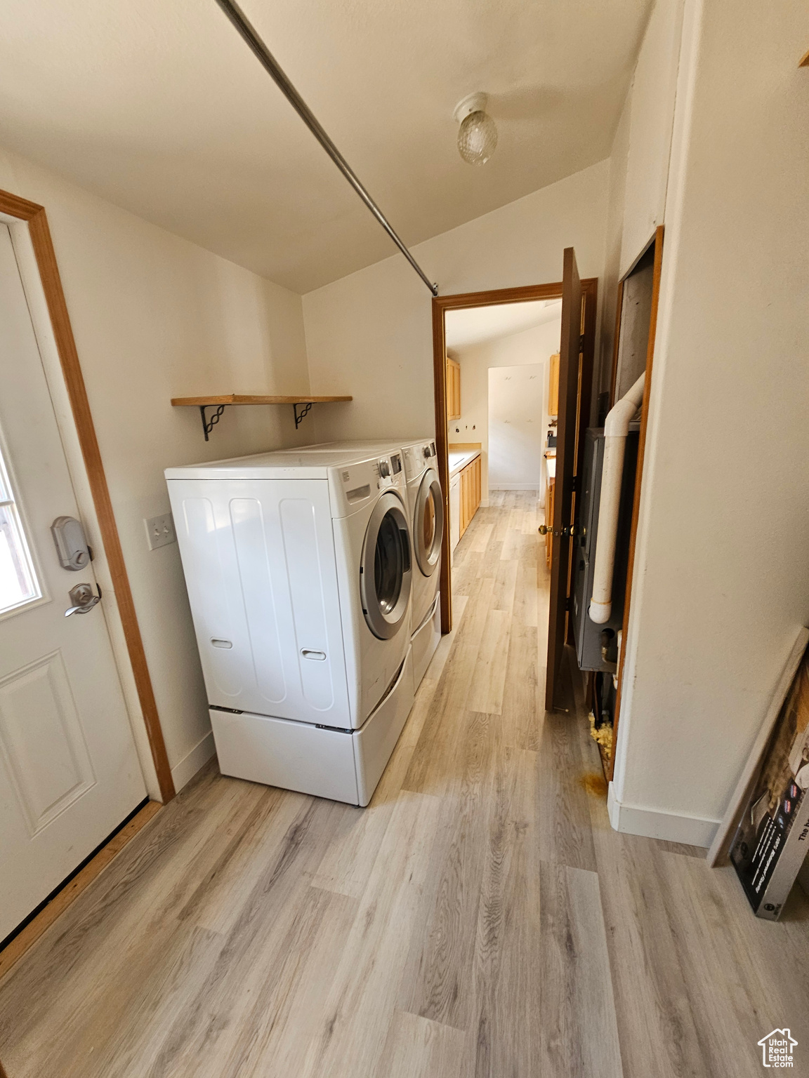 Washroom featuring washing machine and clothes dryer and light hardwood / wood-style floors