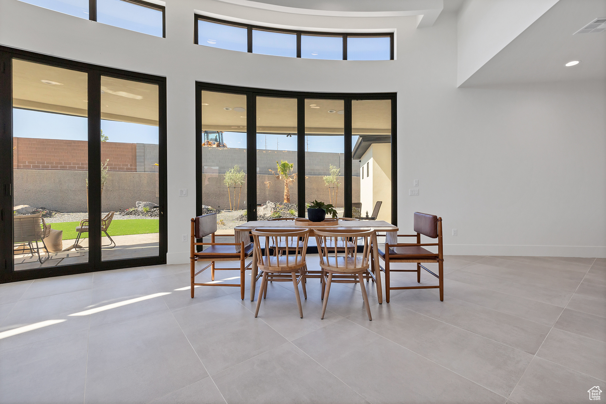 Dining room featuring a wealth of natural light, light tile patterned floors, and a high ceiling