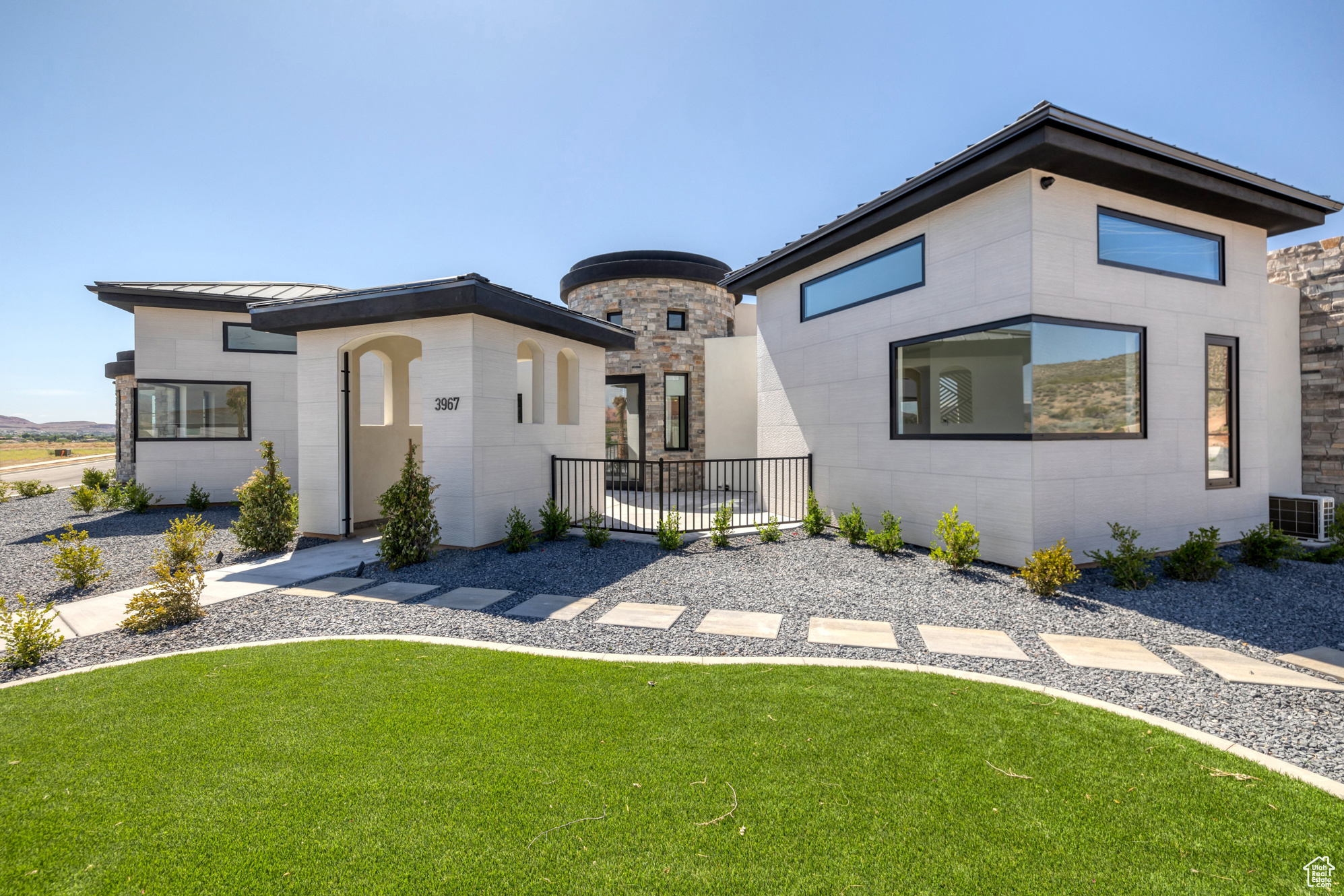 View of front of property with central air condition unit and a front yard