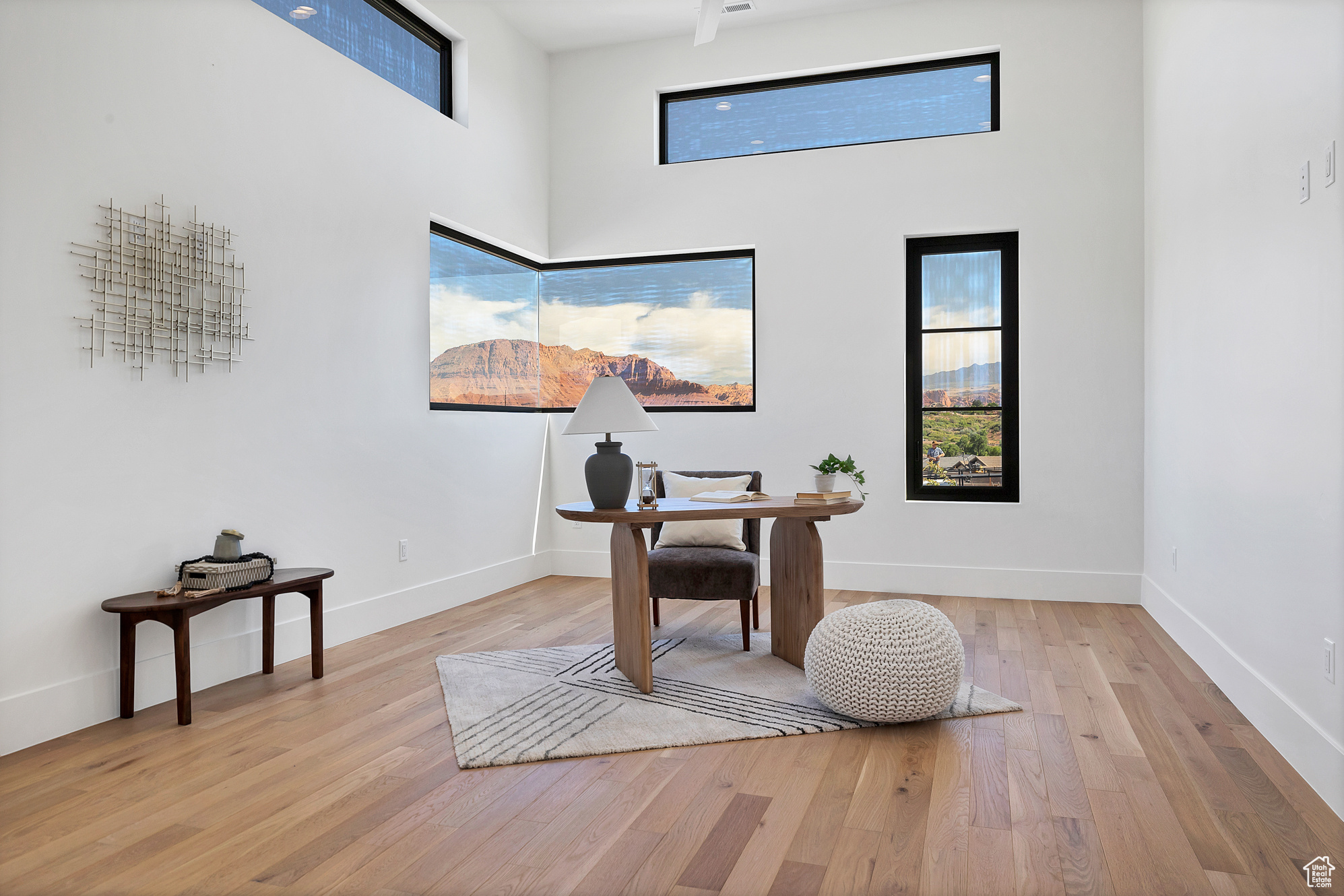 Office space featuring light wood-type flooring and a high ceiling