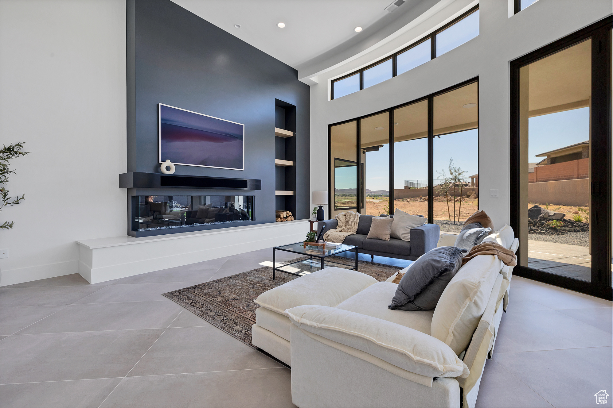 Tiled living room with built in features and a high ceiling