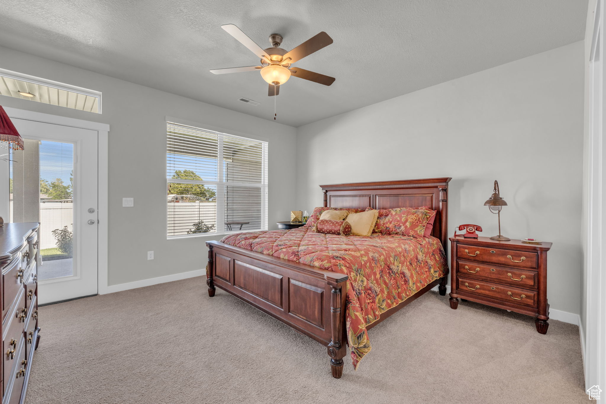 Carpeted bedroom with access to exterior and ceiling fan