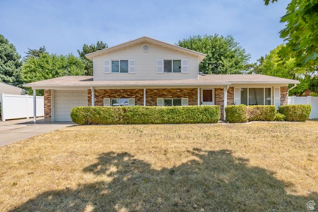 View of front of house featuring a garage, a porch, and a front lawn