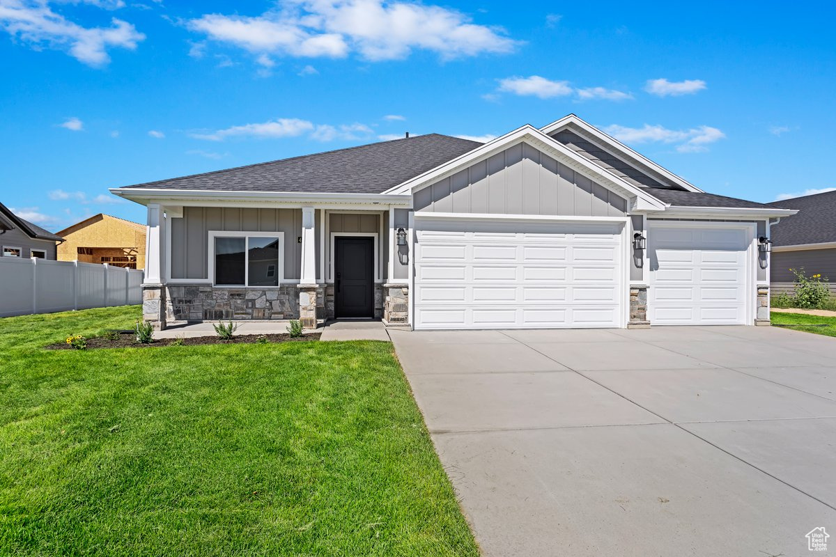 View of front of property featuring a front yard and a garage