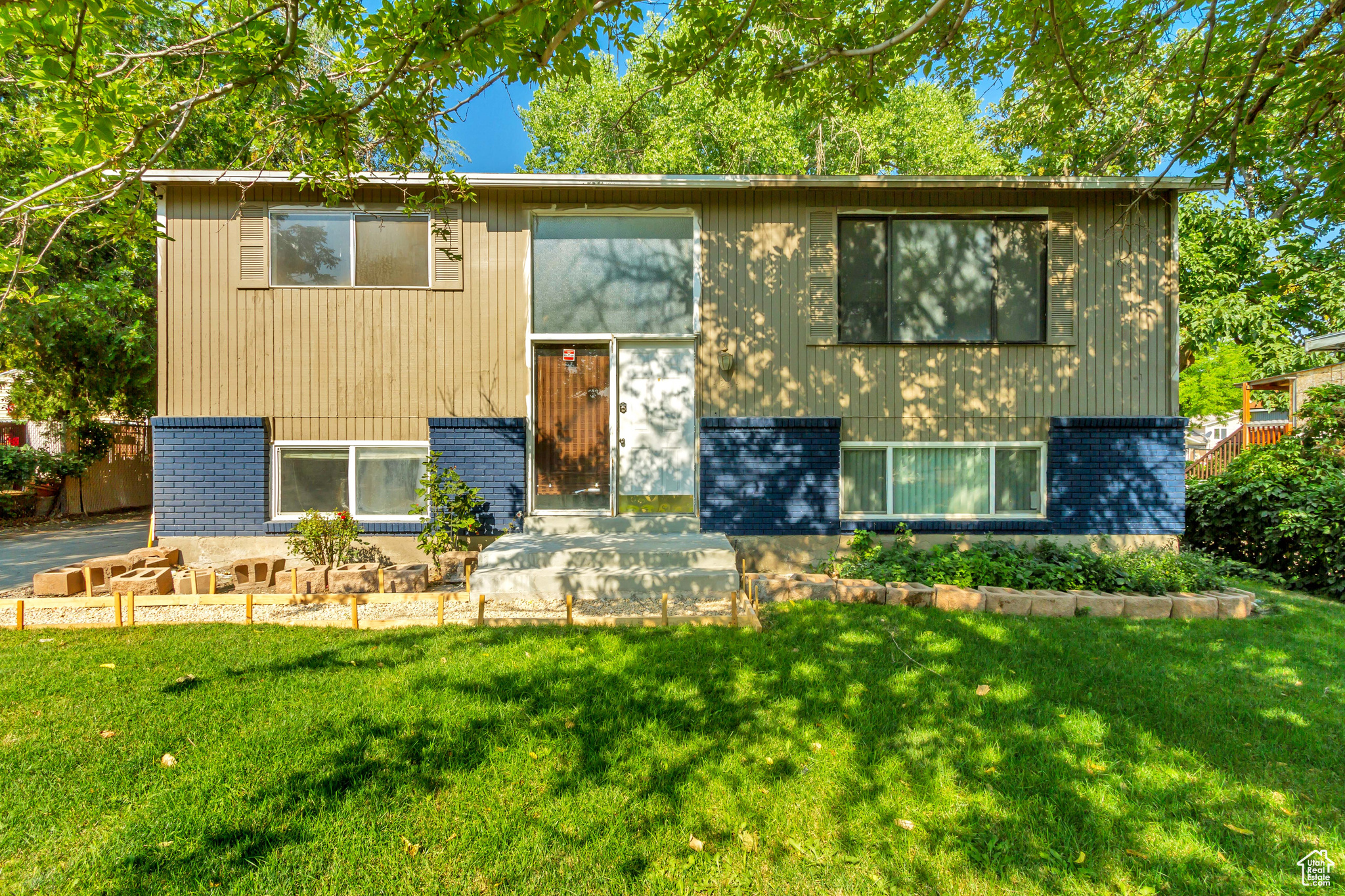 Split entry featuring a front lawn with sprinklers