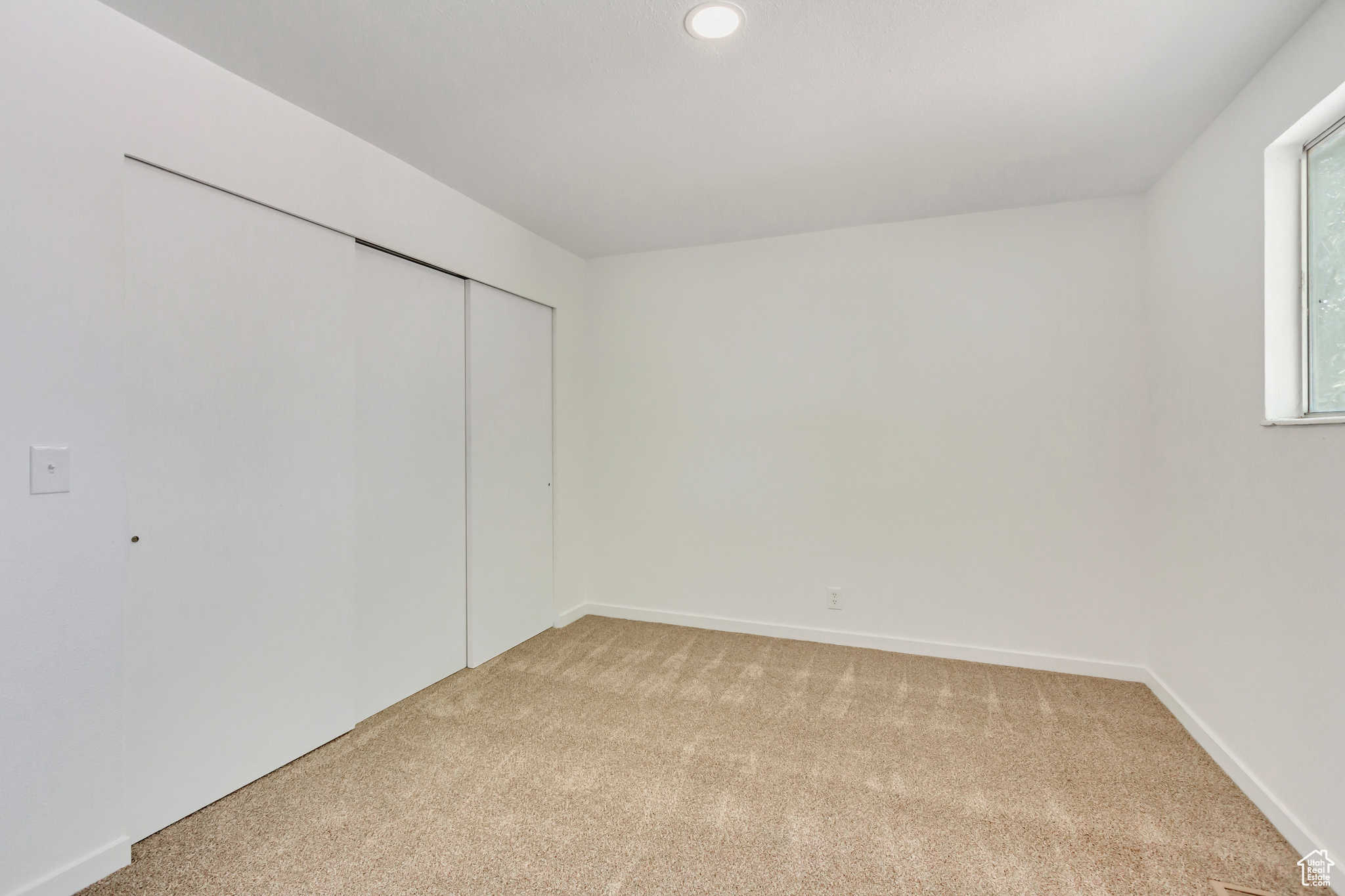 Master bedroom featuring light colored carpet and a closet