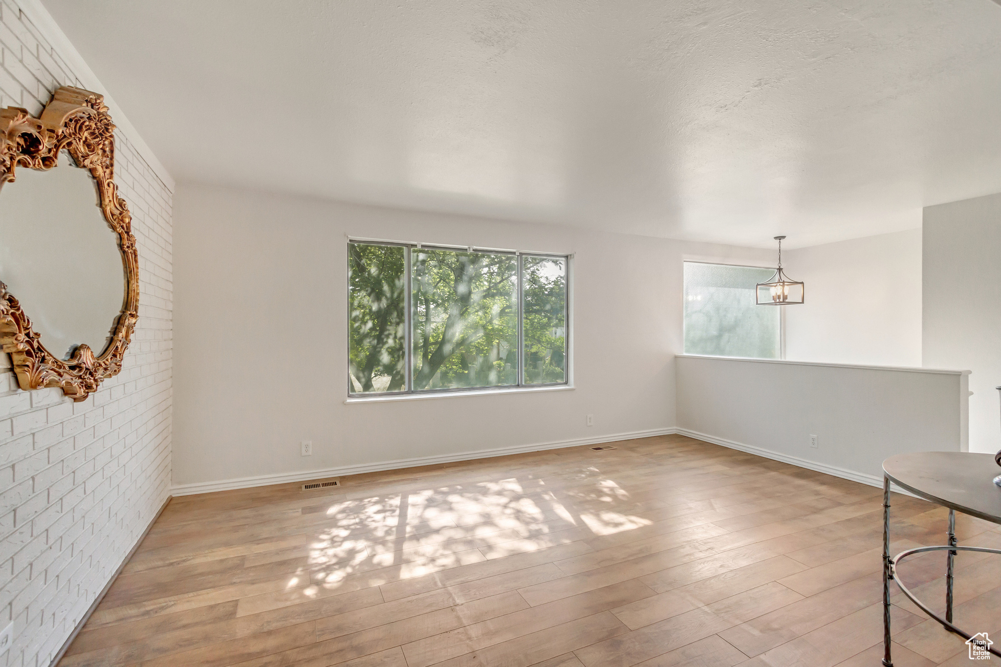 Living room with brick wall and light wood-type flooring