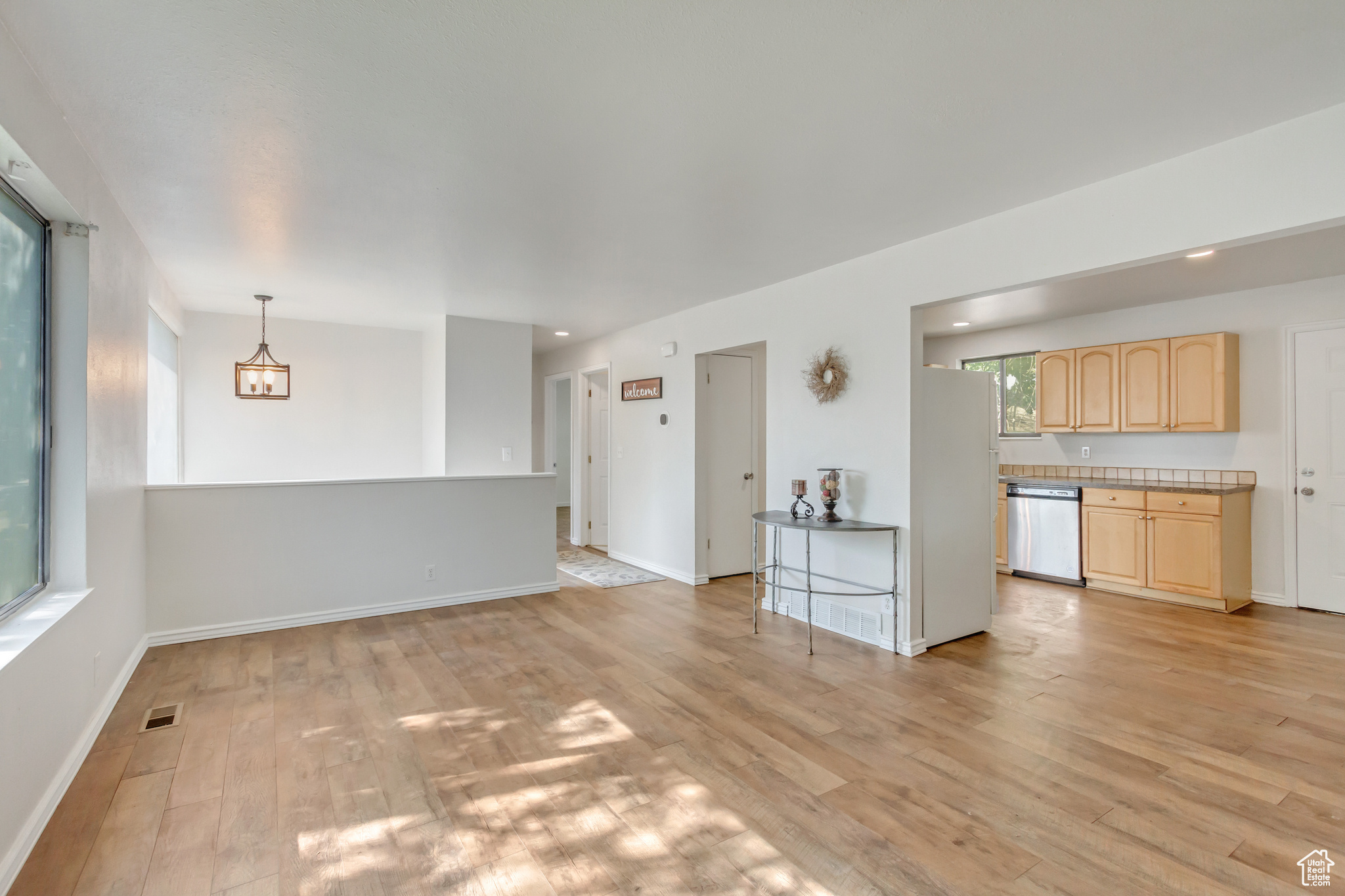 Living room with a chandelier, light hardwood / wood-style floors, and a wealth of natural light