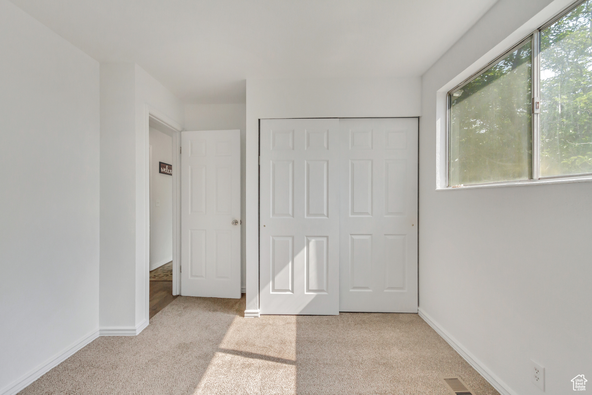 Upstairs bedroom with a closet and light colored carpet