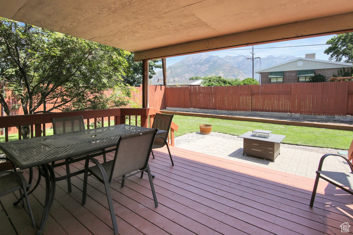 Deck featuring a mountain view, a patio, a yard, and an outdoor fire pit