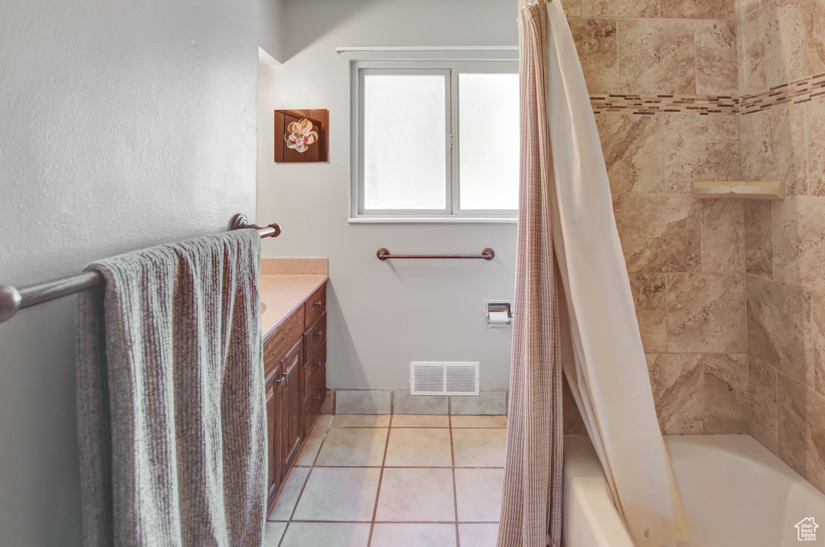 Bathroom featuring vanity, tile patterned flooring, and shower / bath combo