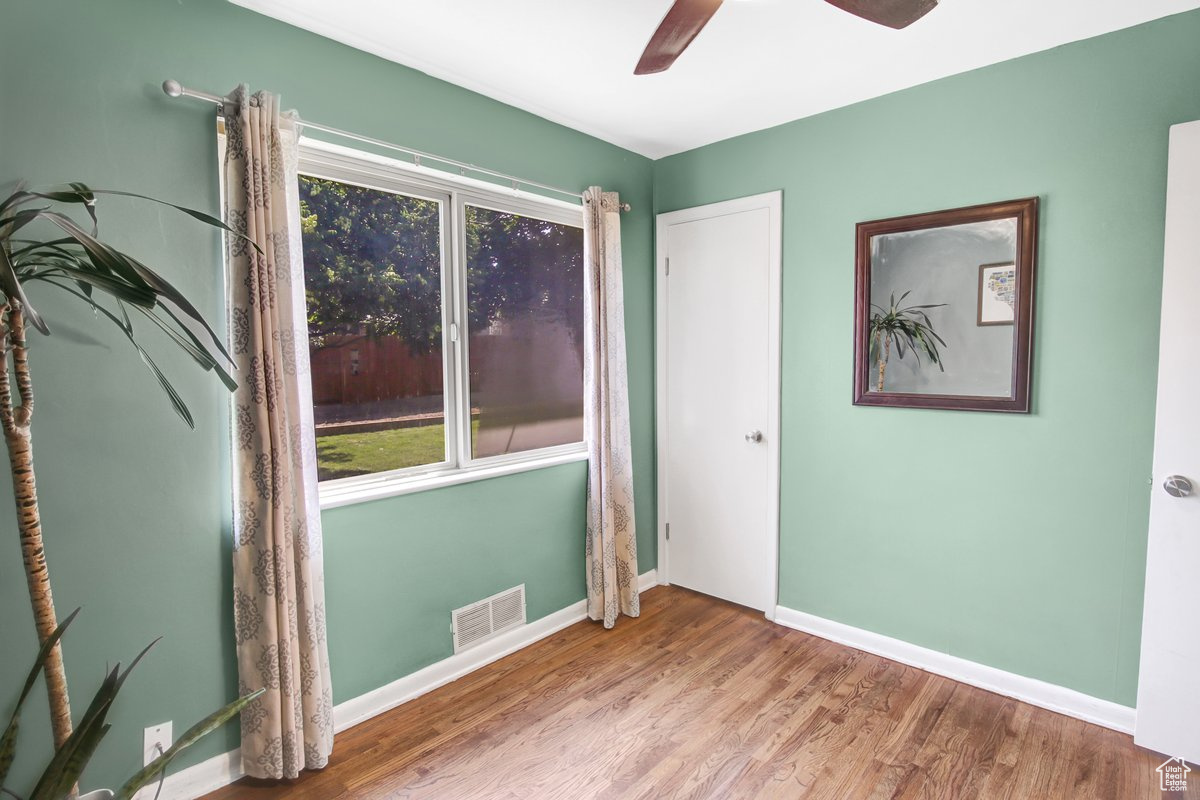 Empty room featuring hardwood / wood-style flooring and ceiling fan