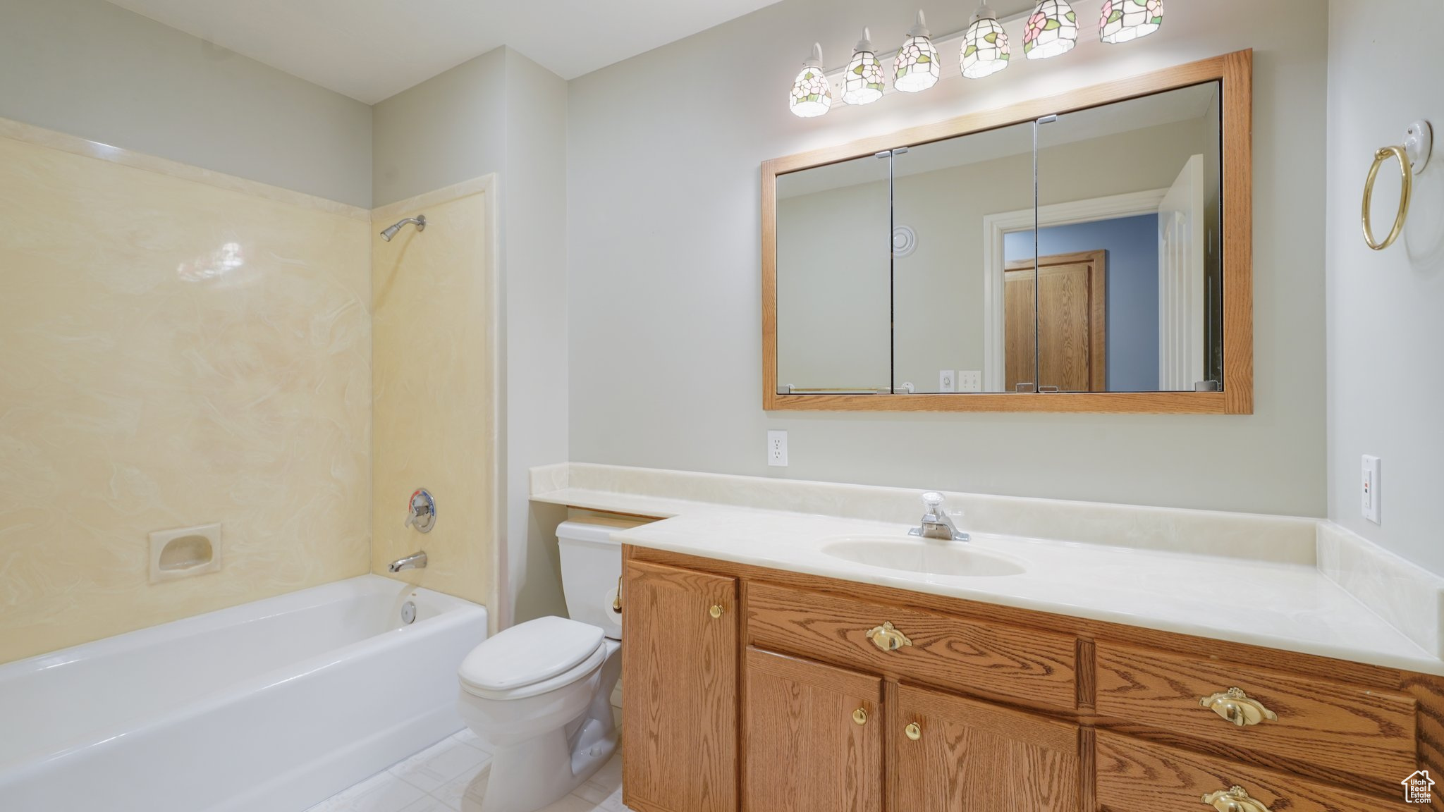 Full bathroom with tile patterned flooring, toilet, vanity, and shower / tub combination