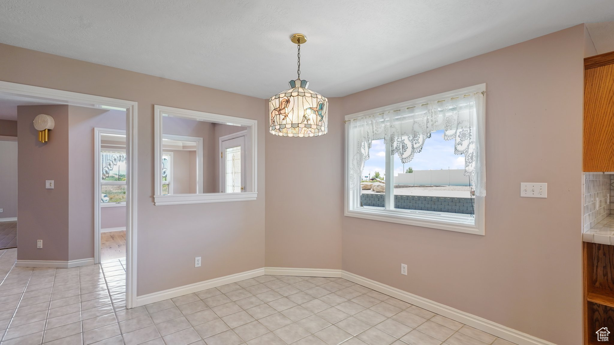 Unfurnished dining area with a notable chandelier and light tile patterned floors