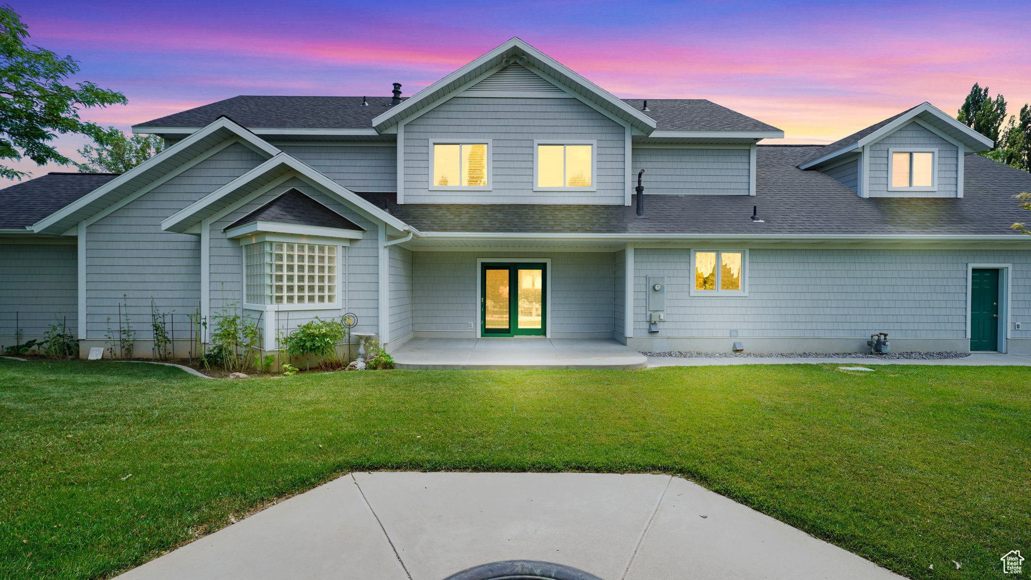 View of front of house with a patio area and a yard