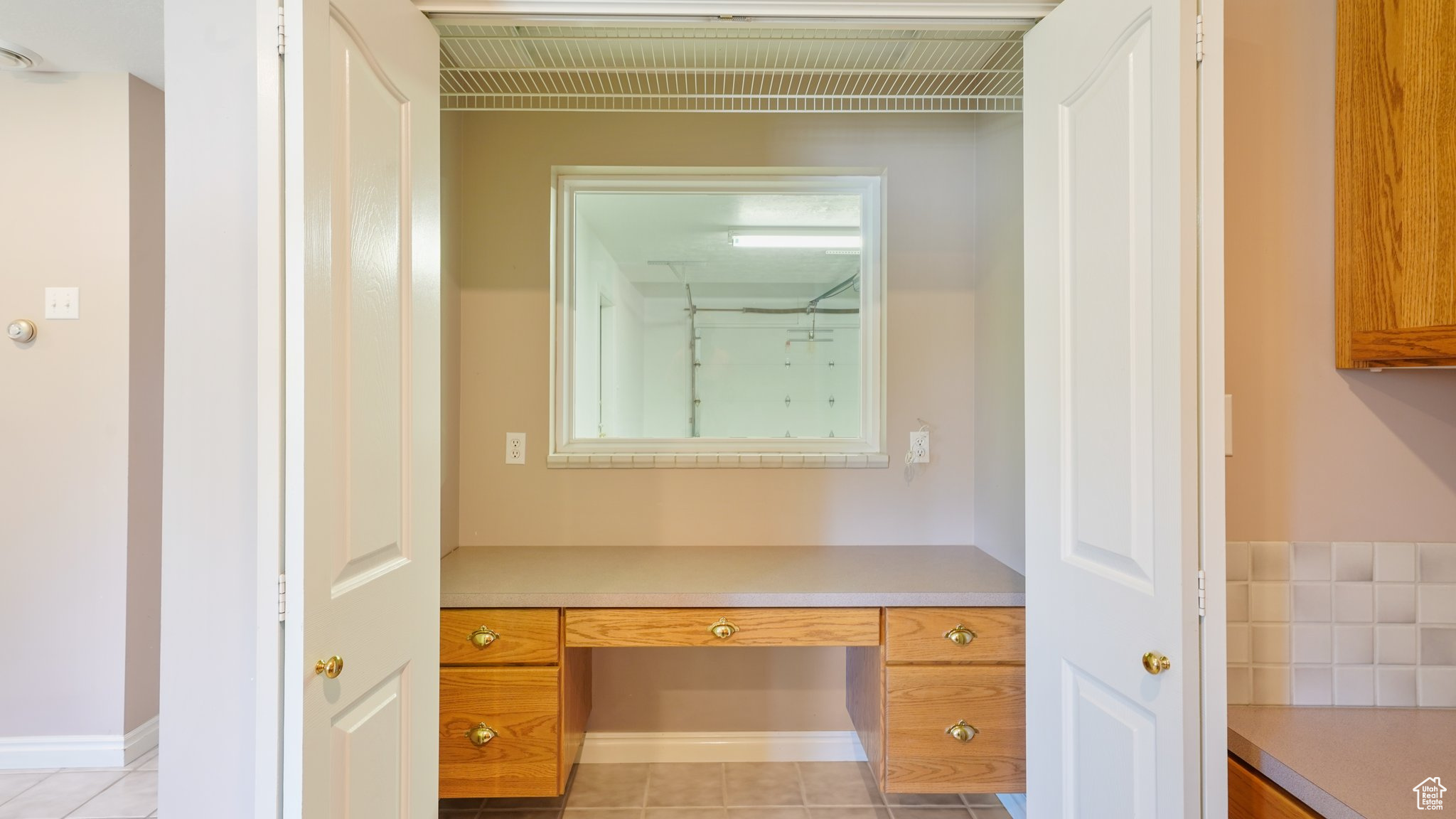 Laundry room with built in desk and light tile patterned floors