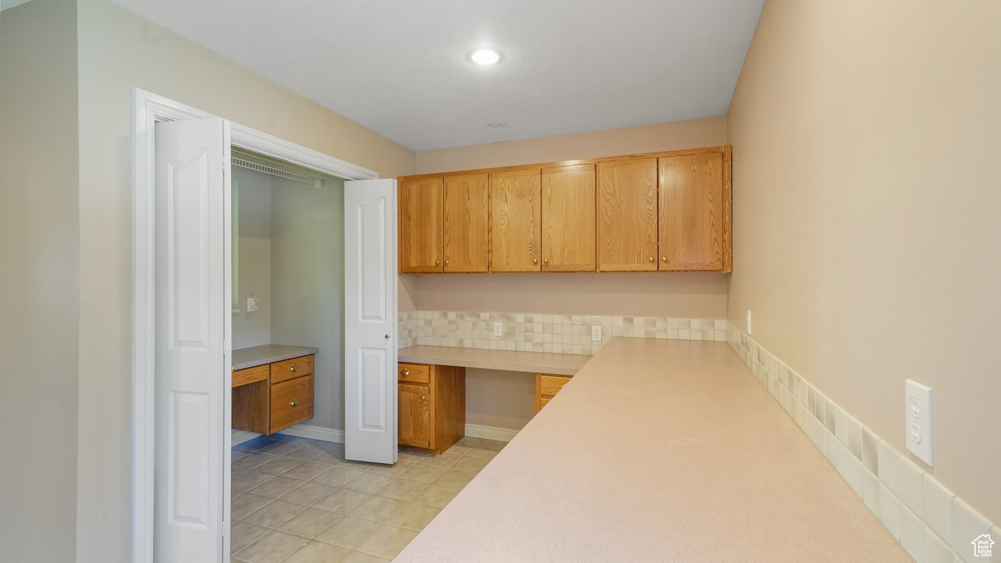 Laundry with built in desk and light tile patterned floors