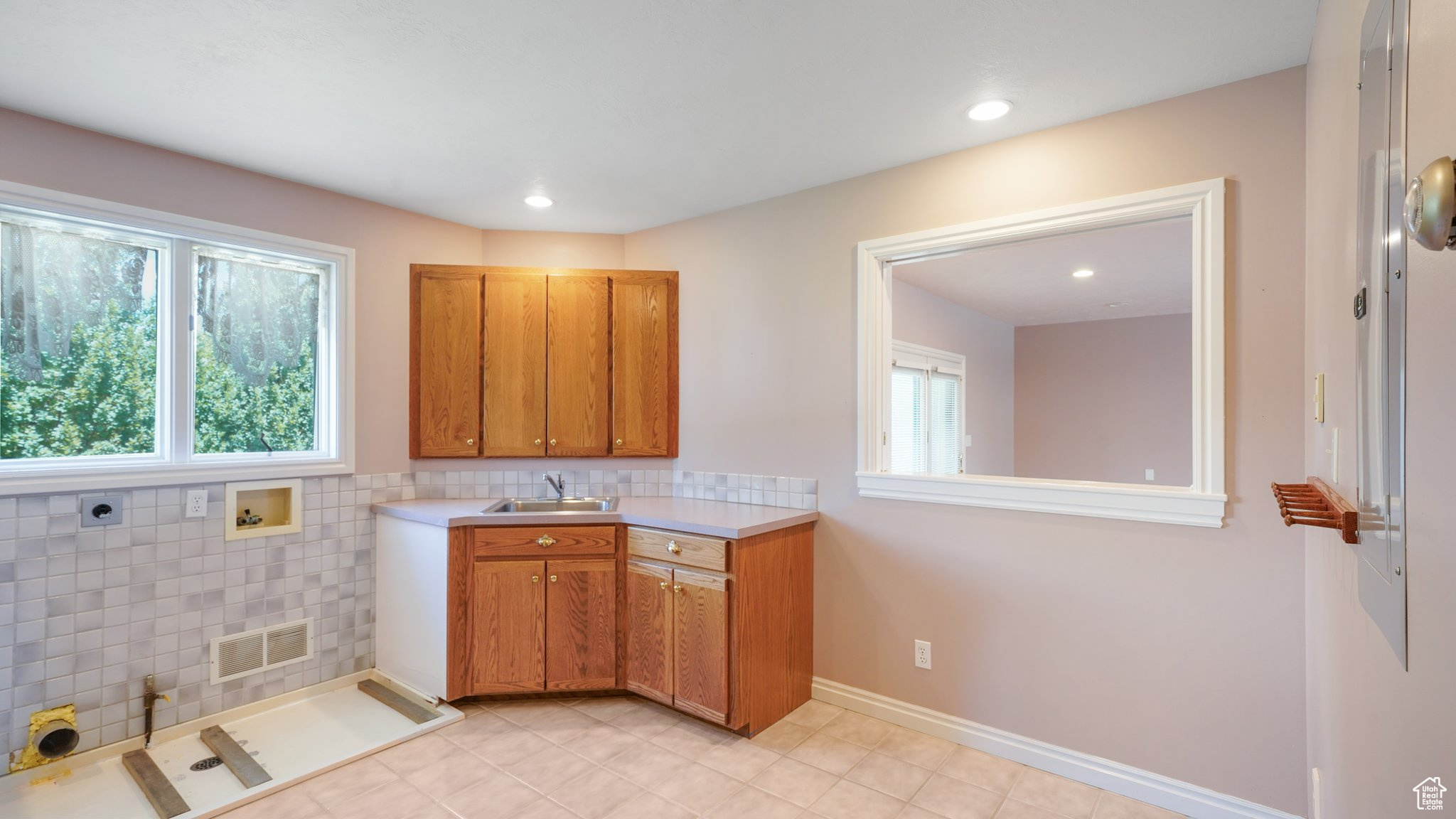 Laundry with light tile patterned flooring and sink