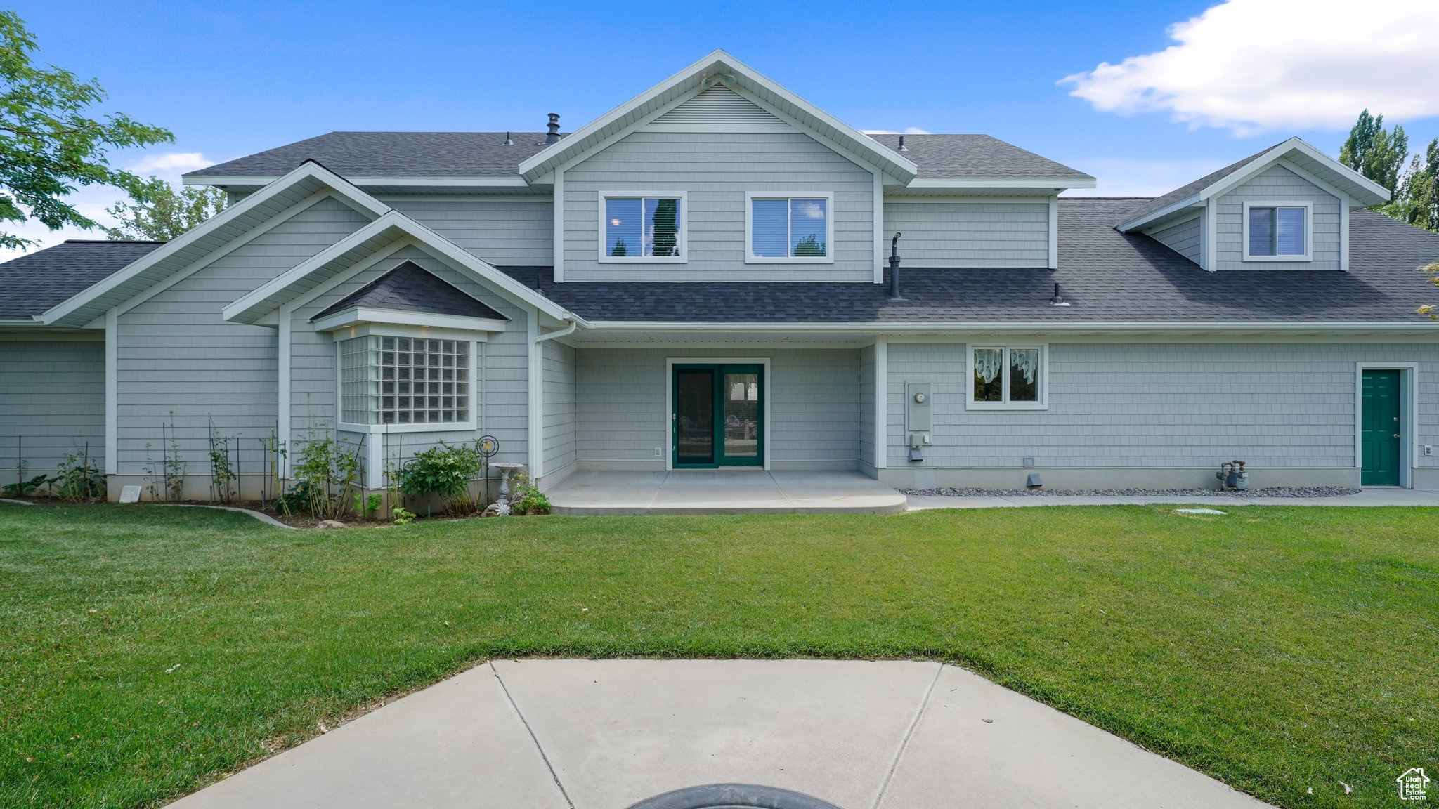 Back of property with a patio area and a lawn