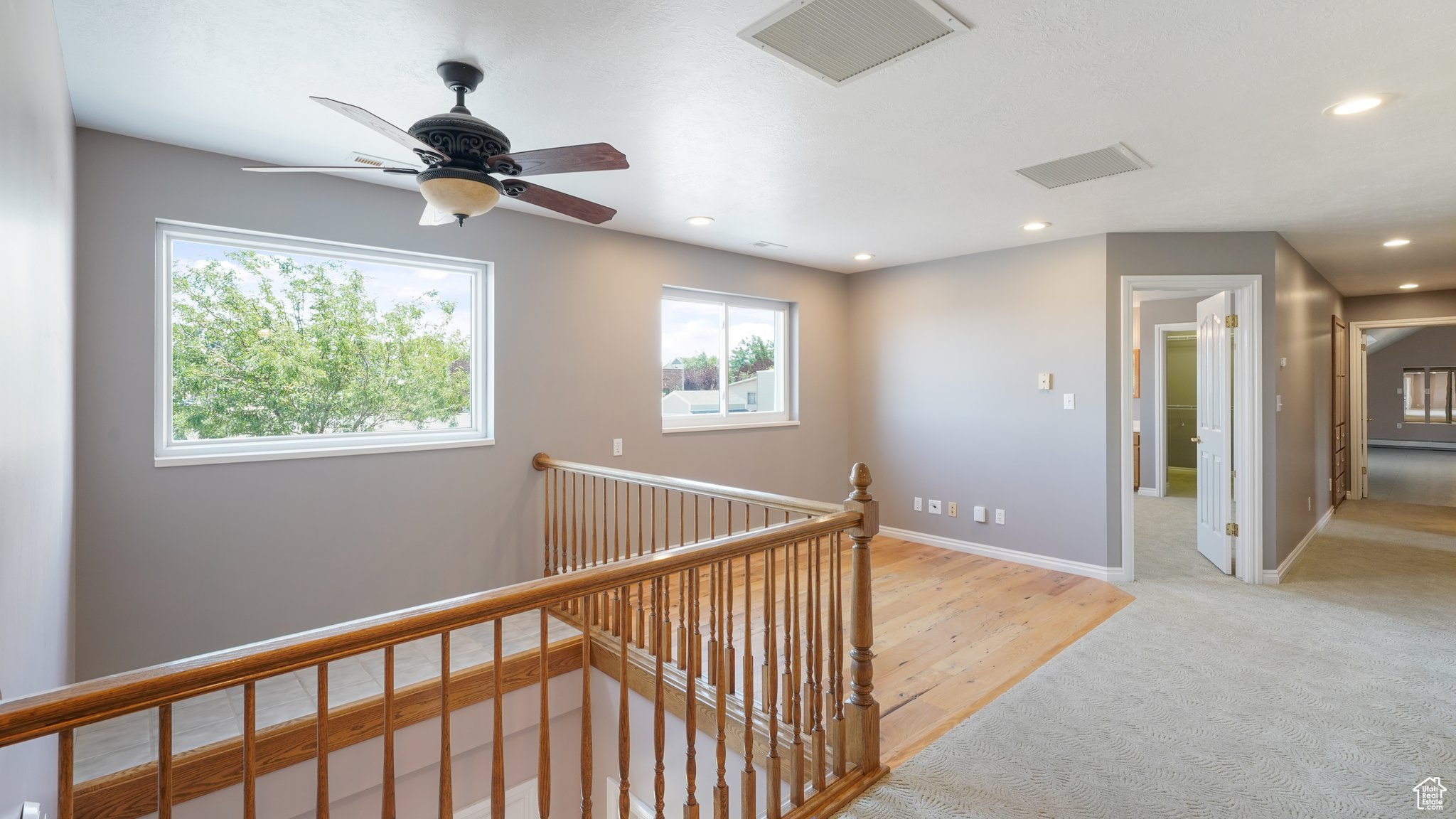 Corridor with light colored carpet and plenty of natural light